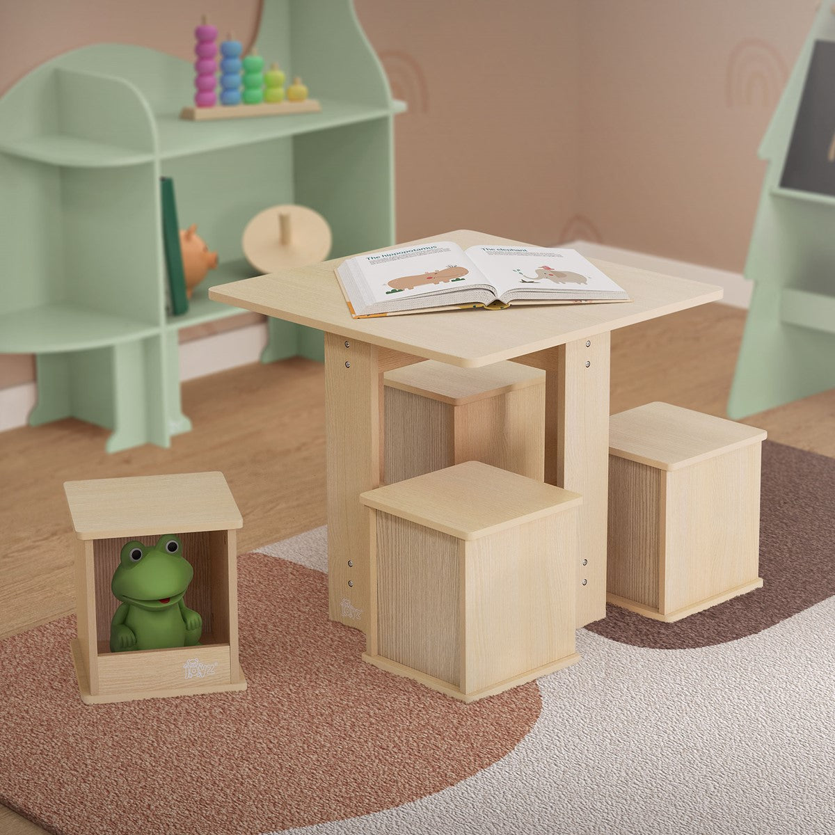 Wooden table with four stools and a book on the tabletop, toys in the background.