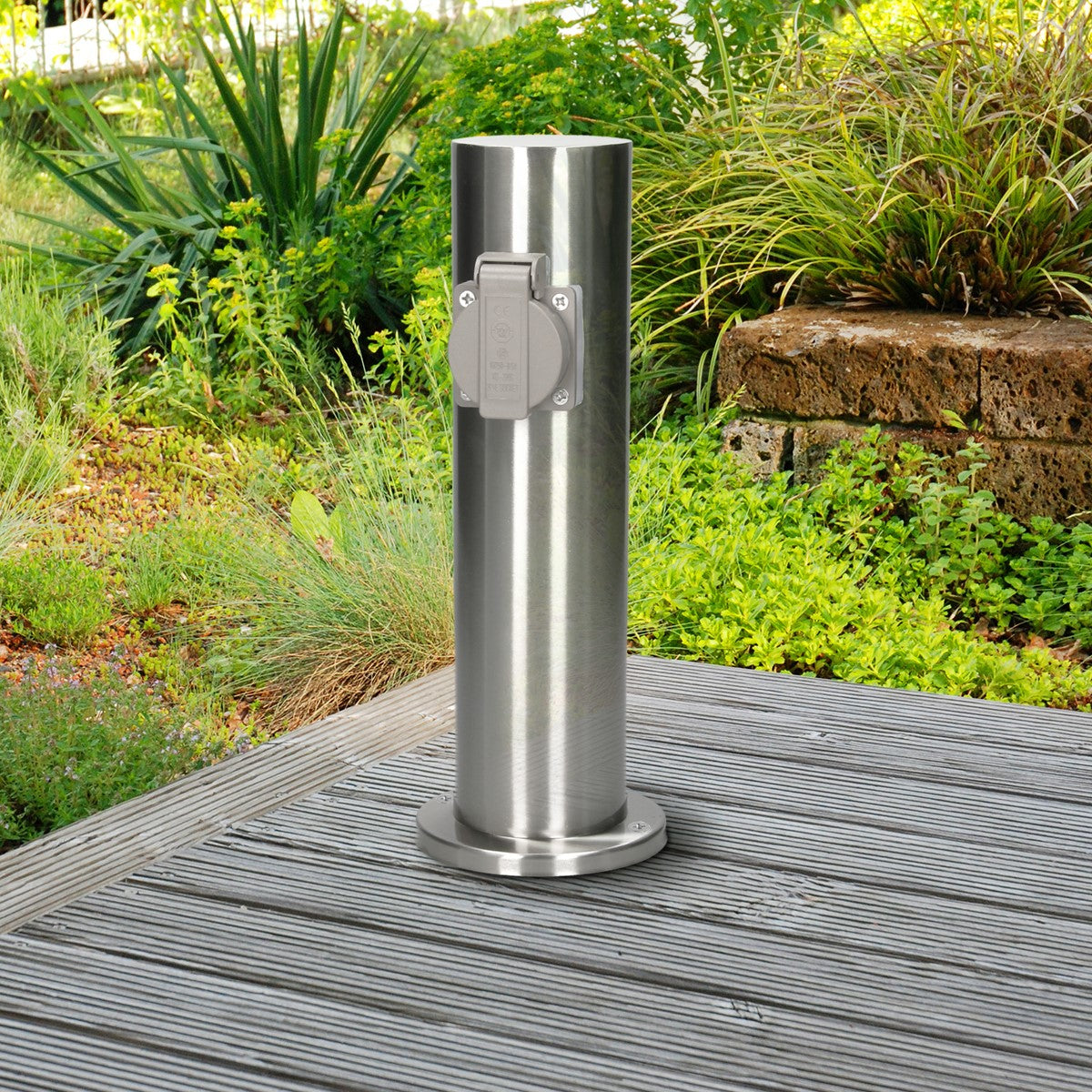 A silver power distributor on a wooden deck, surrounded by plants.