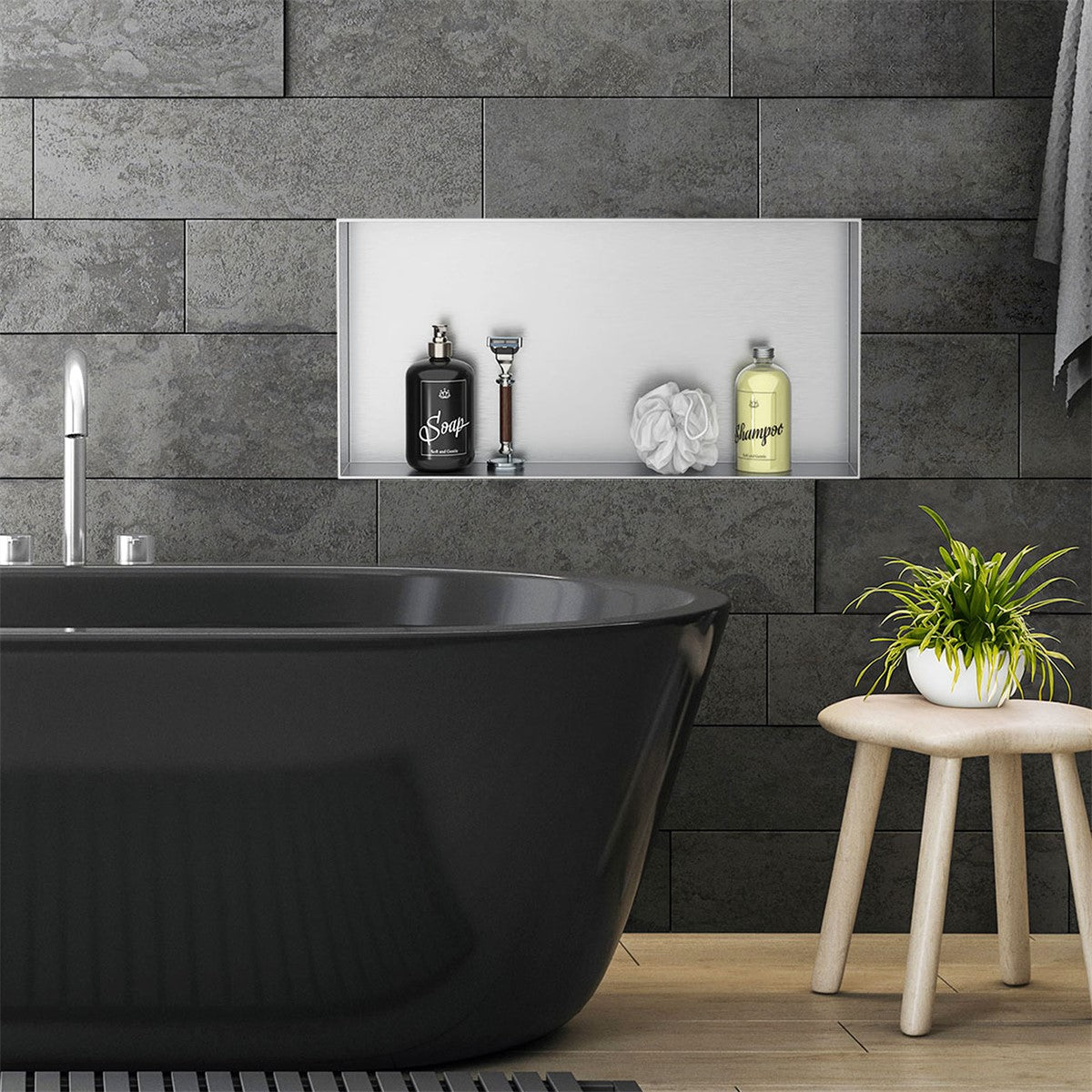 Black bathtub with care products and a small plant on a wooden stool.
