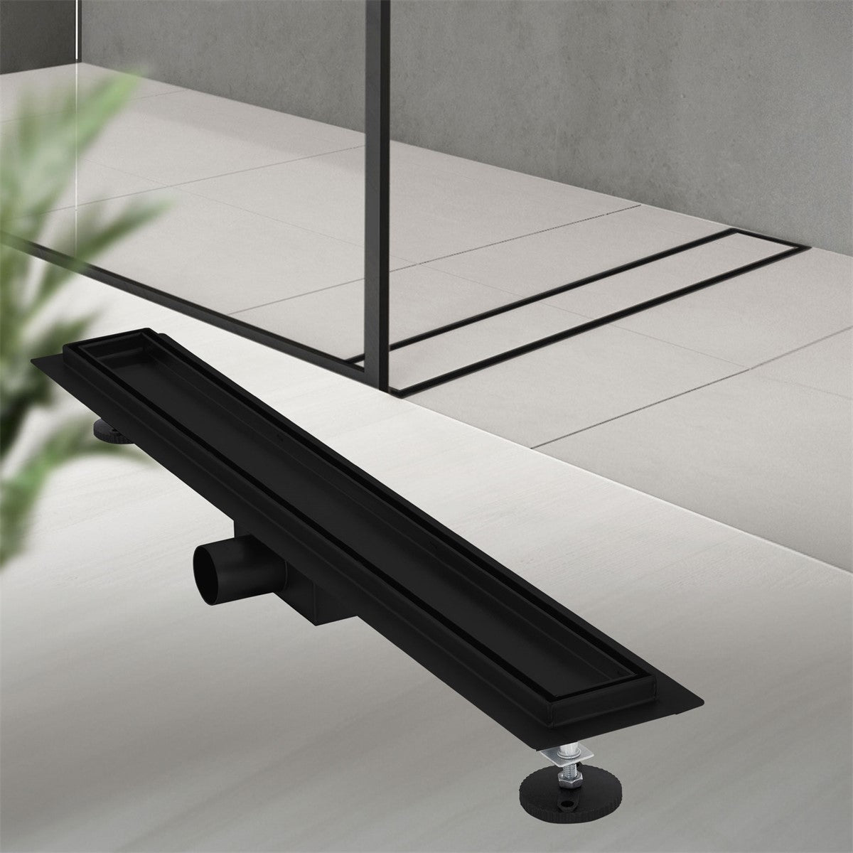 Black shower drain on a light-colored floor, with a glass shower screen in the background.