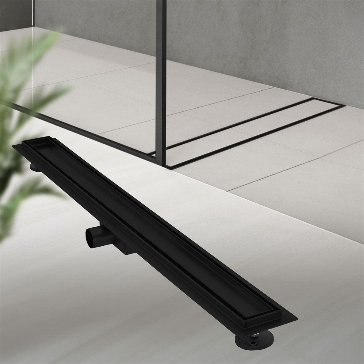 Black shower drain on a light-colored floor, surrounded by plants.