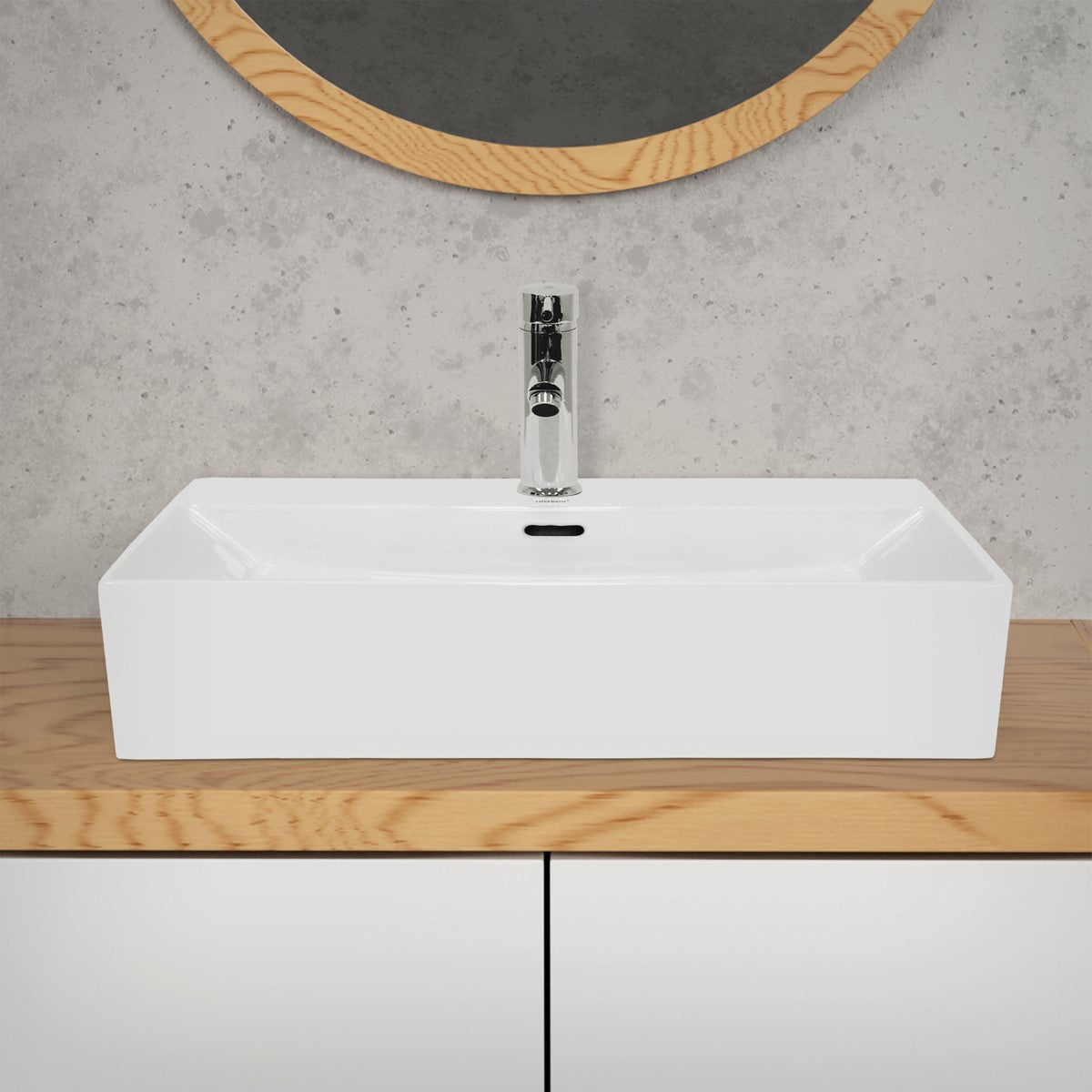 Weißes Waschbecken auf einem Holzregal vor einer grauen Wand mit runder Spiegelumrandung.