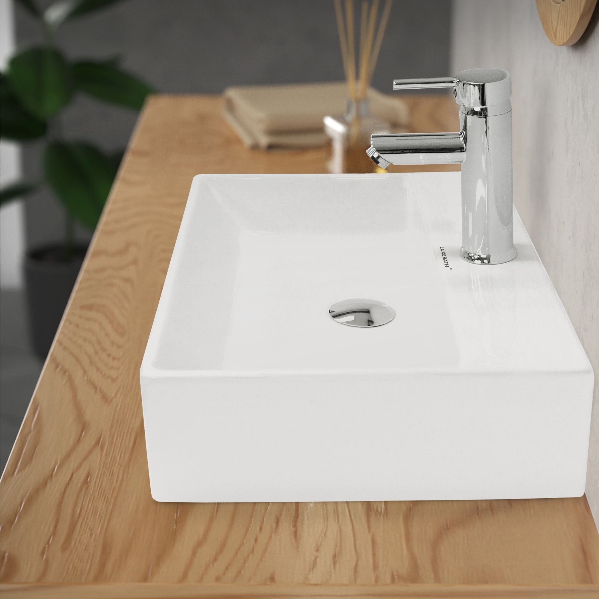 Weißes Waschbecken auf einer Holzoberfläche mit Wasserhahn.