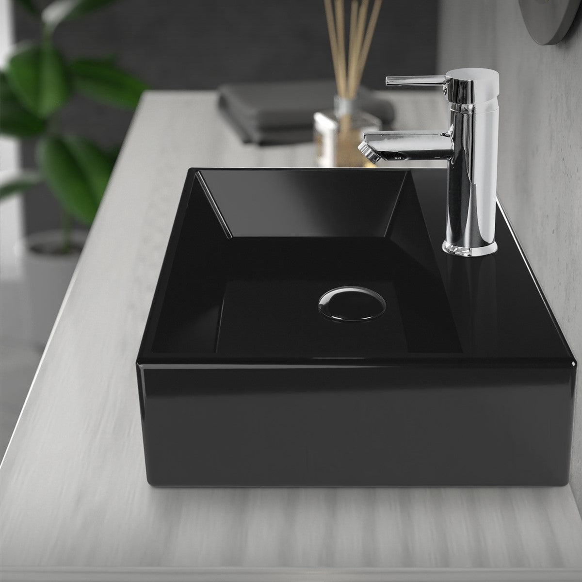 Lavabo nero con rubinetto e scarico in un bagno moderno.