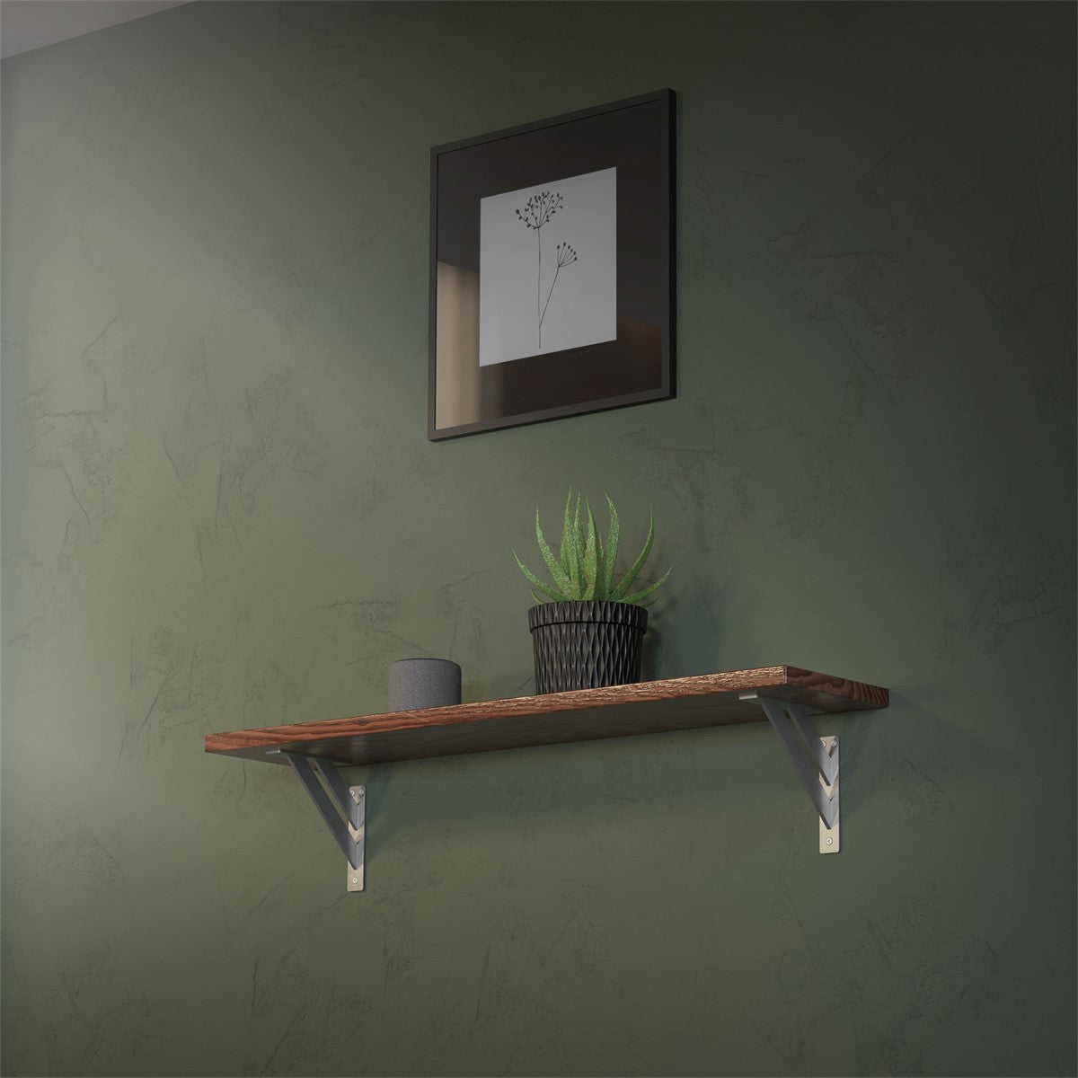 Shelf on a green wall with a plant and a framed picture above it.