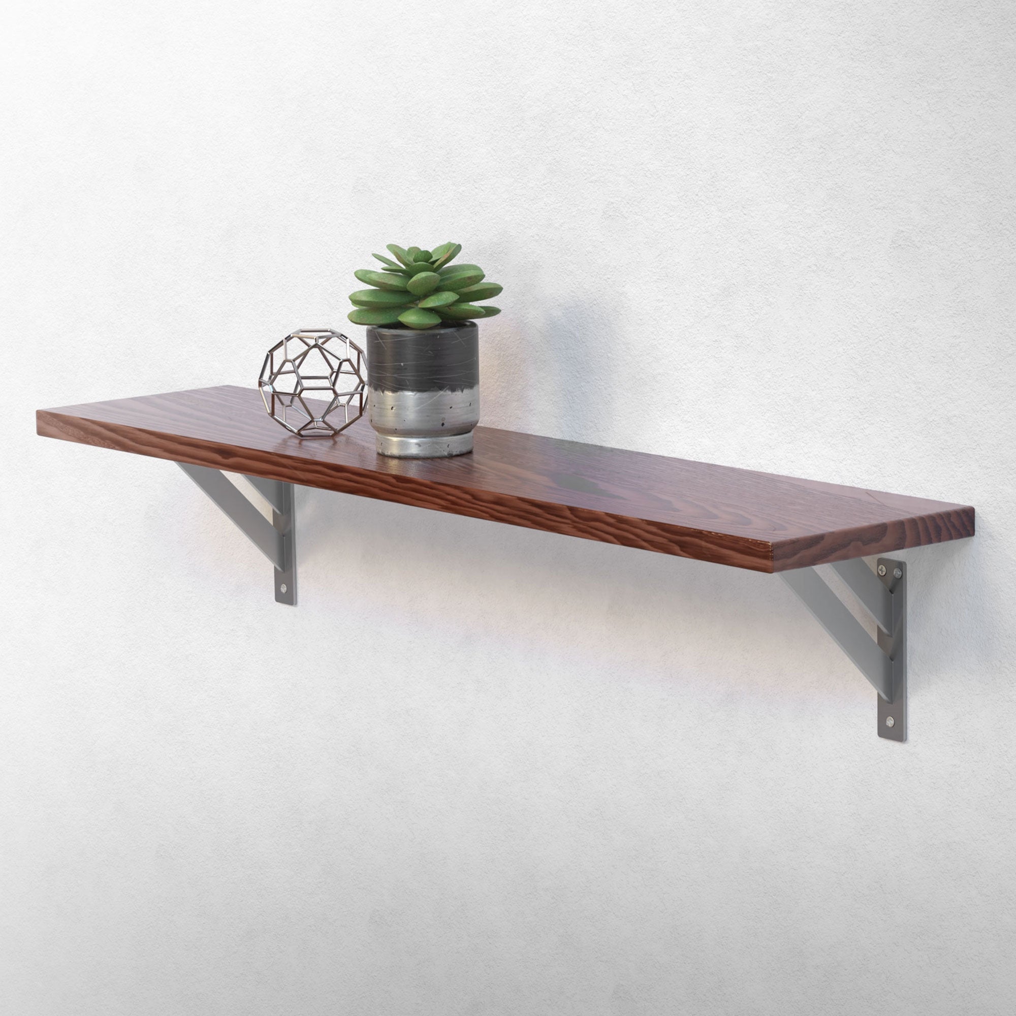 Houten plank met plant en decoratie aan een muur.