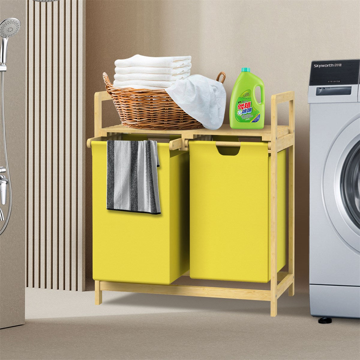 Laundry basket with two compartments, towels and laundry detergent next to a washing machine.