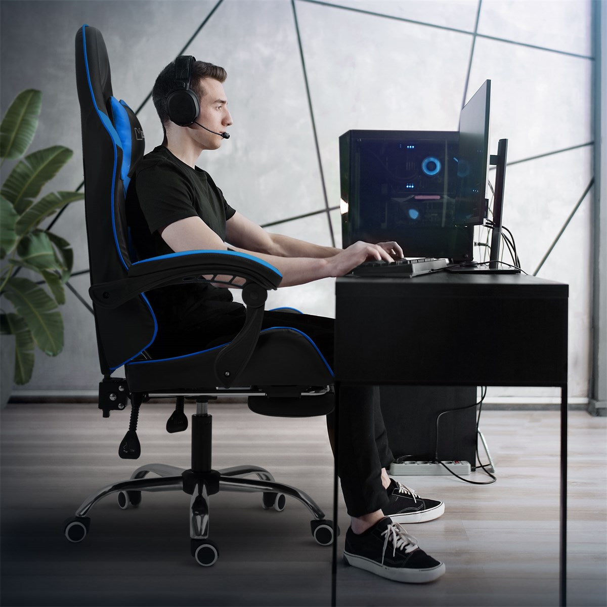 Person sitzt seitlich an einem Schreibtisch in einem Gaming-Stuhl.