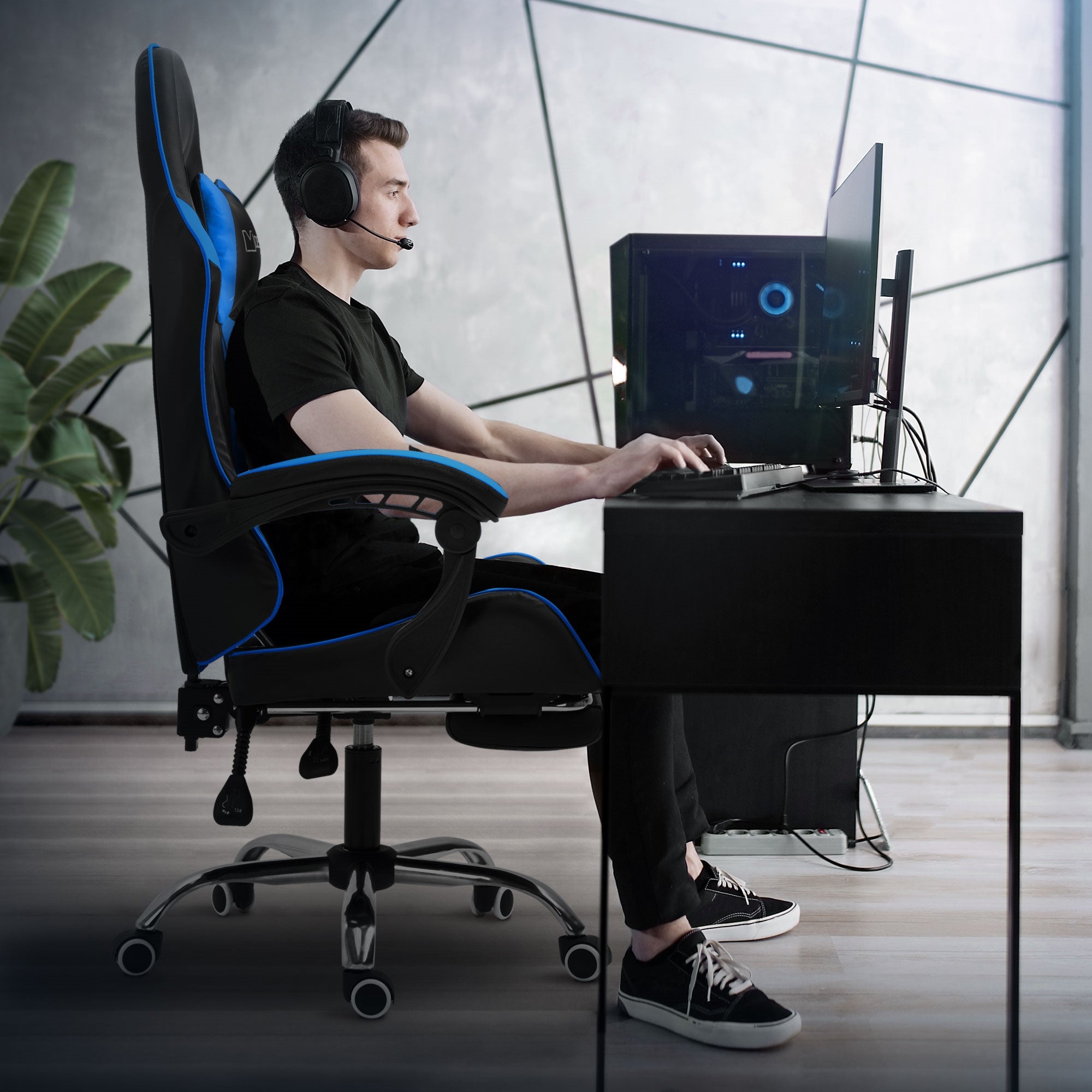 Egy személy oldalról ül egy íróasztalnál gamer széken.