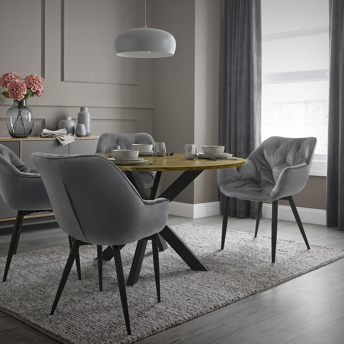 Esszimmer mit grauen Stühlen, runder Tisch und dekorativen Elementen.