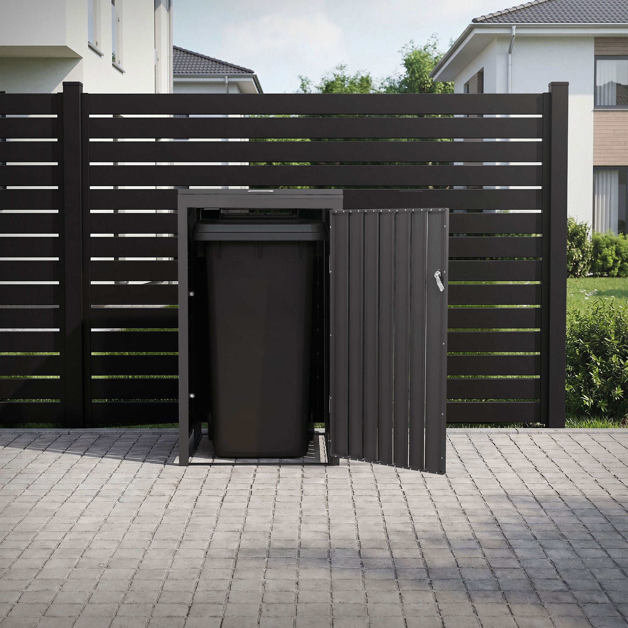 Schwarze Mülltonnenbox mit offenem Deckel, hinter einem Zaun in einem Garten.