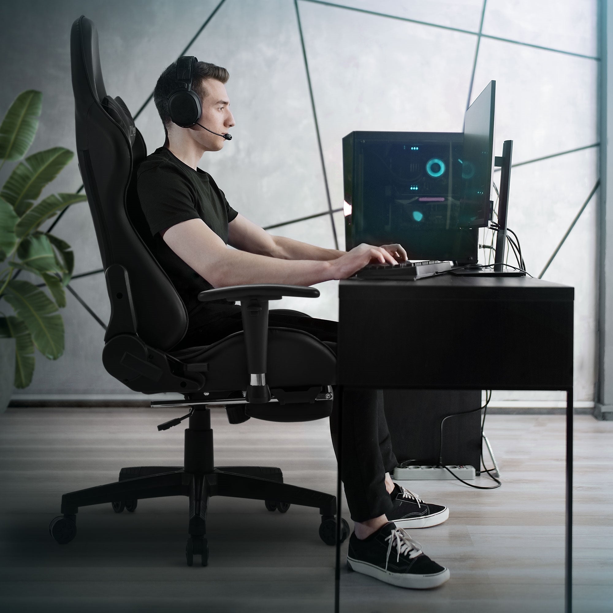 Mann mit Headset sitzt an einem Schreibtisch in einem Gaming-Stuhl.