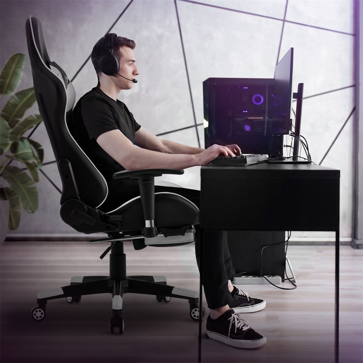 Egy férfi íróasztalnál ül egy gaming székben, és headsetet visel.