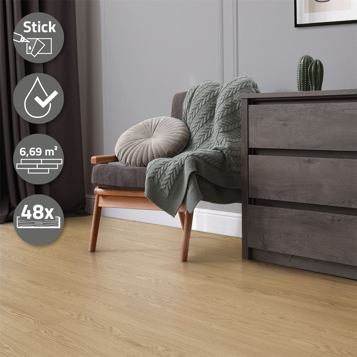 A gray sofa with a blanket and a cushion, with a wooden cabinet beside it.