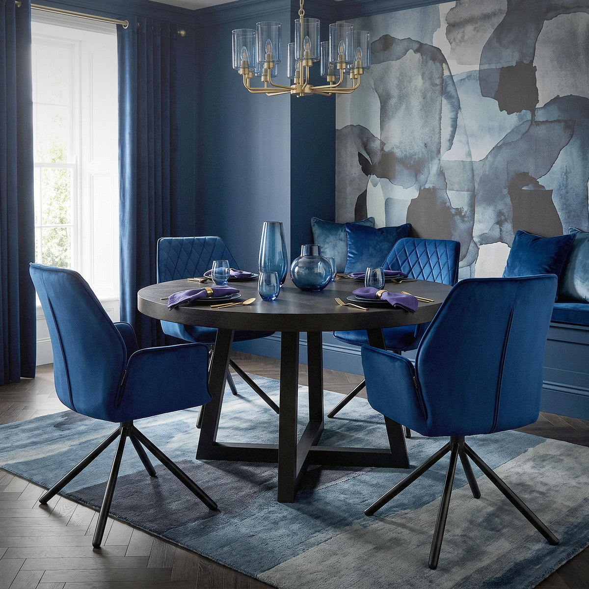 Mesa redonda con sillas azules en un elegante comedor.