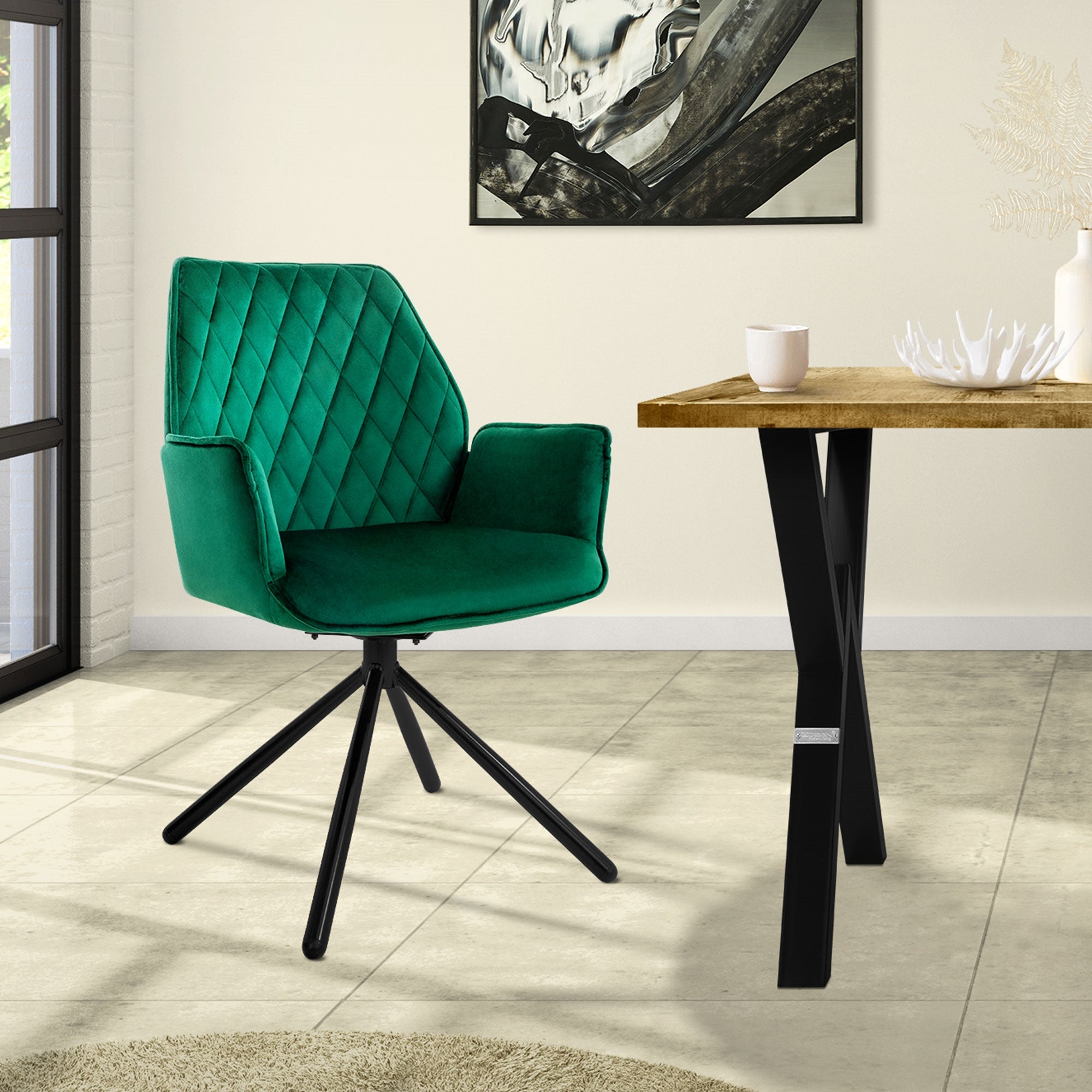 Silla verde frente a una mesa en una habitación con grandes ventanas.