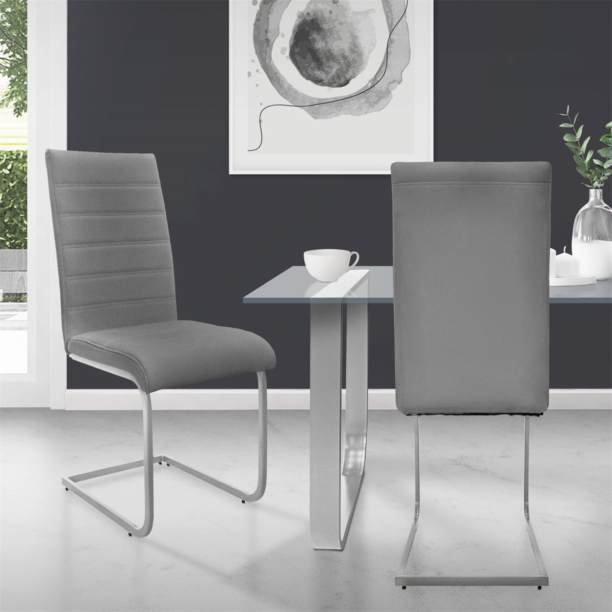Two gray chairs at a table with a glass top in a modern room.