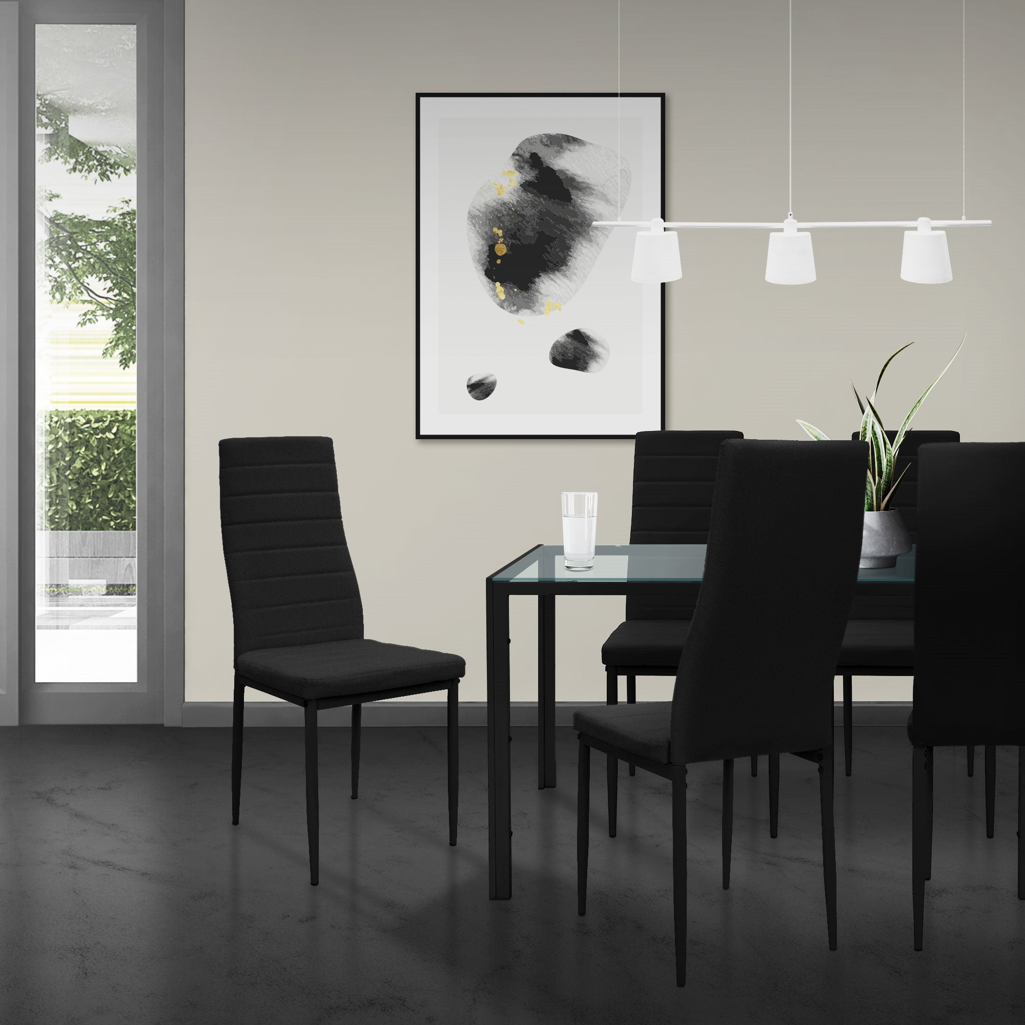 Sala da pranzo con tavolo nero e quattro sedie nere, opera d'arte sulla parete.