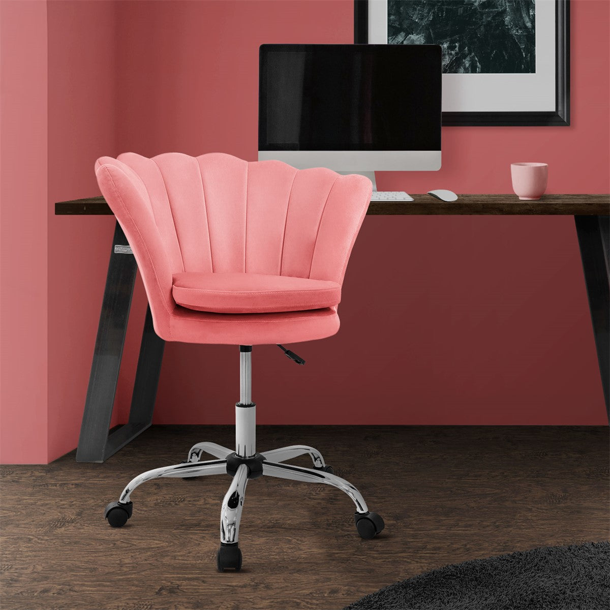 A pink office chair in front of a desk in a room with a red wall.