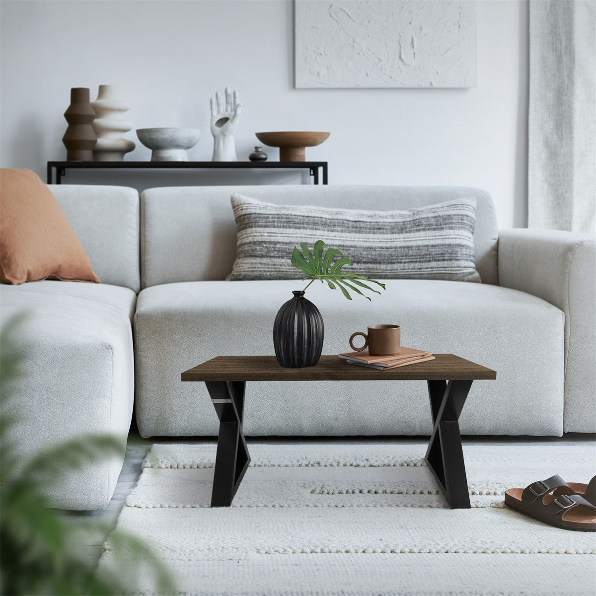 Sala de estar aconchegante com sofá, mesa e uma planta sobre a mesa.