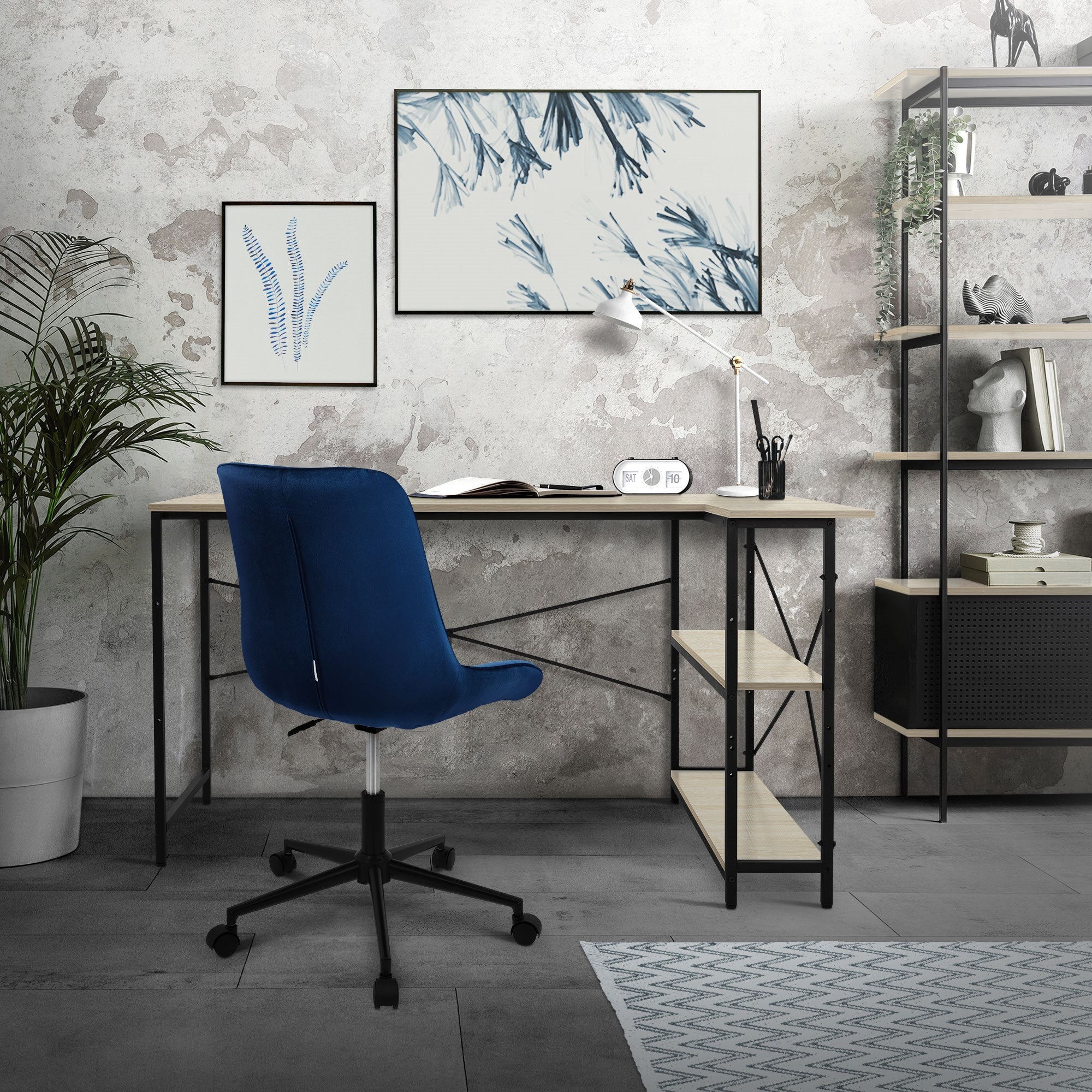 A desk with a blue chair, plants, and pictures on the wall.