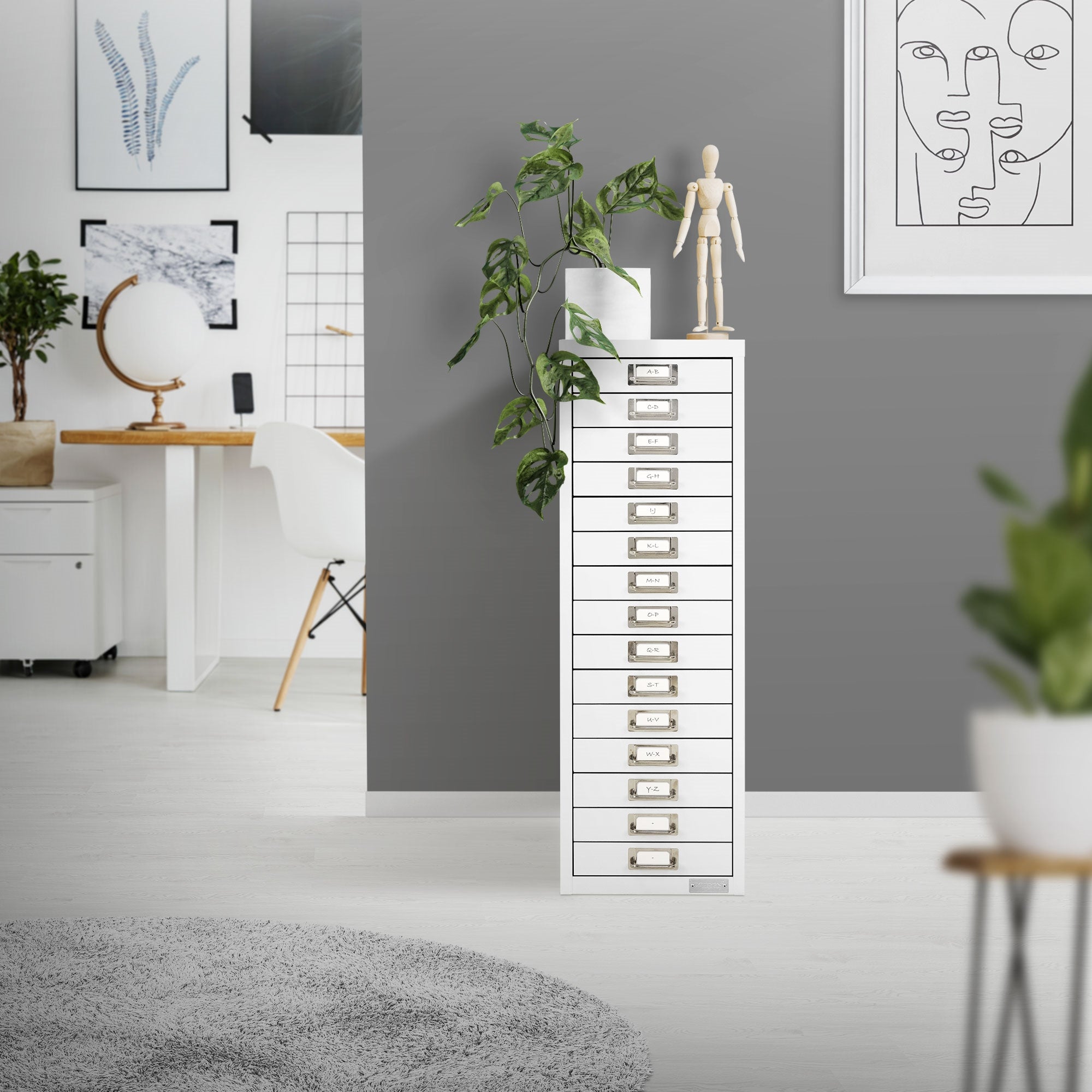 Weißer Aktenschrank in einem hellen Büro mit Pflanzen und Kunst.