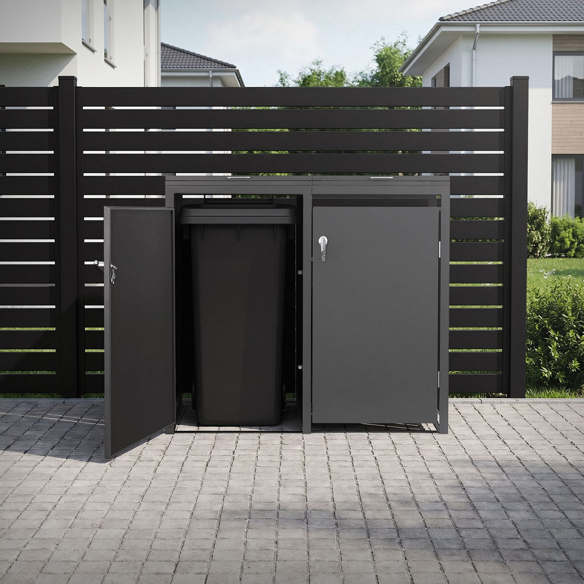 Cajón para cubos de basura con la puerta abierta, en una zona ajardinada con una valla.