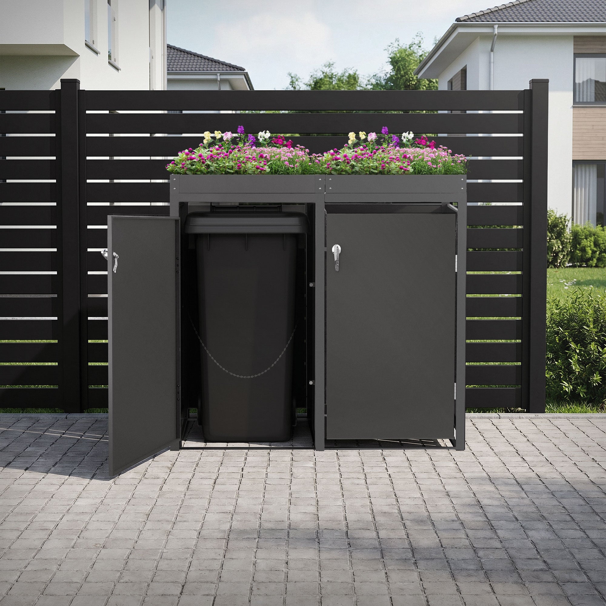 Mülltonnenbox im Garten mit blühenden Pflanzen und offenem Zugang.