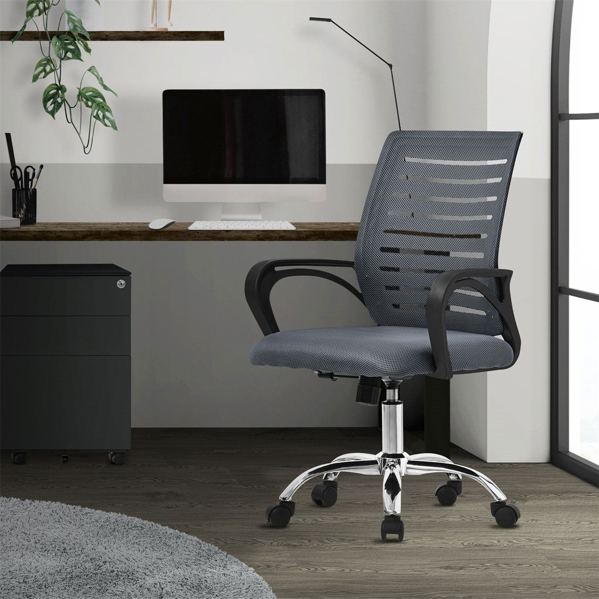 Gray office chair in front of a desk with a computer.