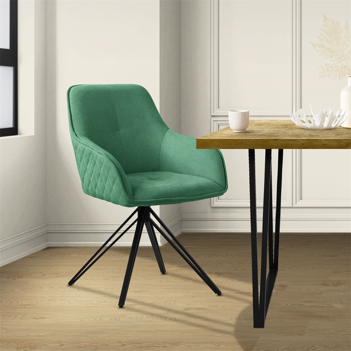 A green chair stands next to a table in a bright room.