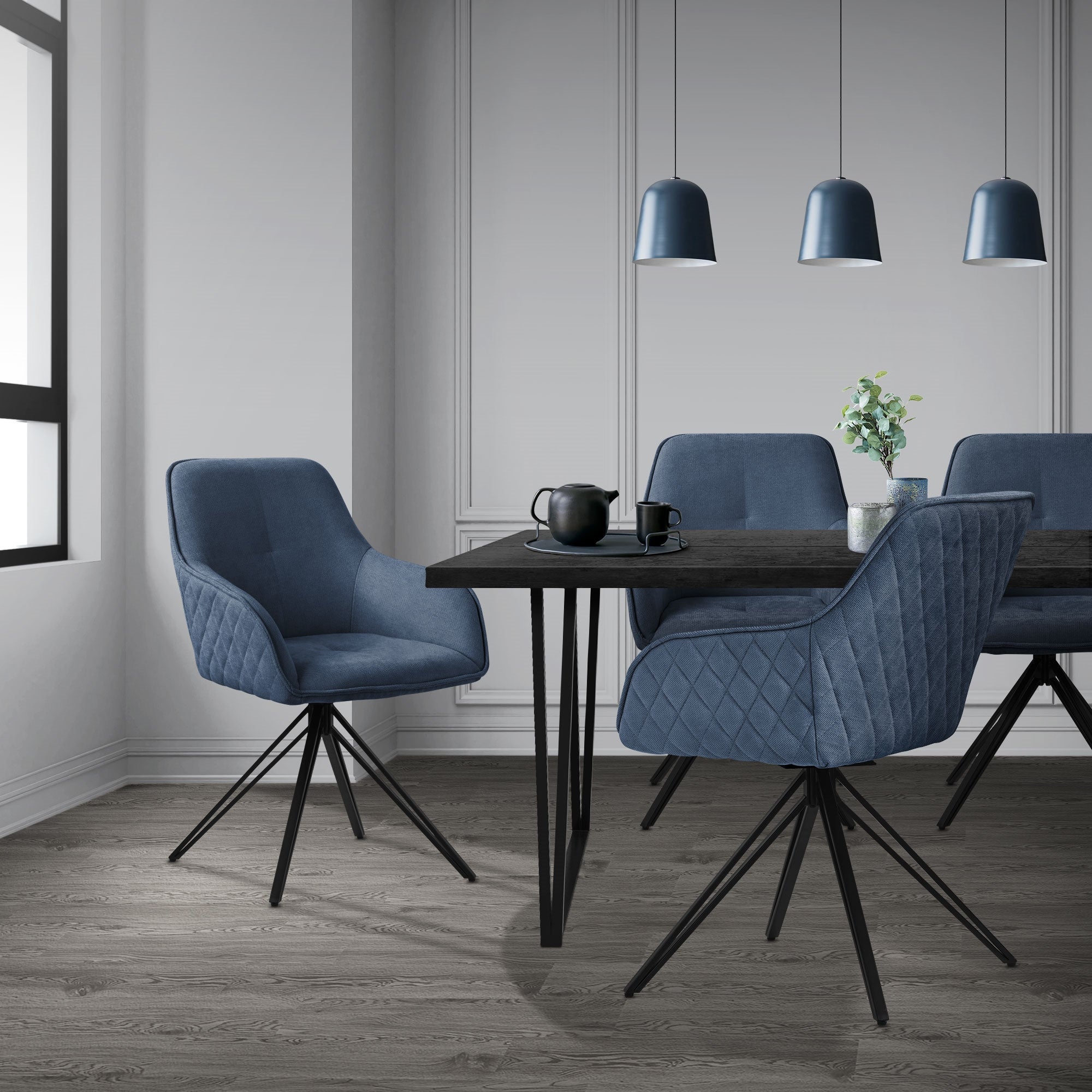 Ein Esszimmer mit einem schwarzen Tisch und vier blauen Stühlen.
