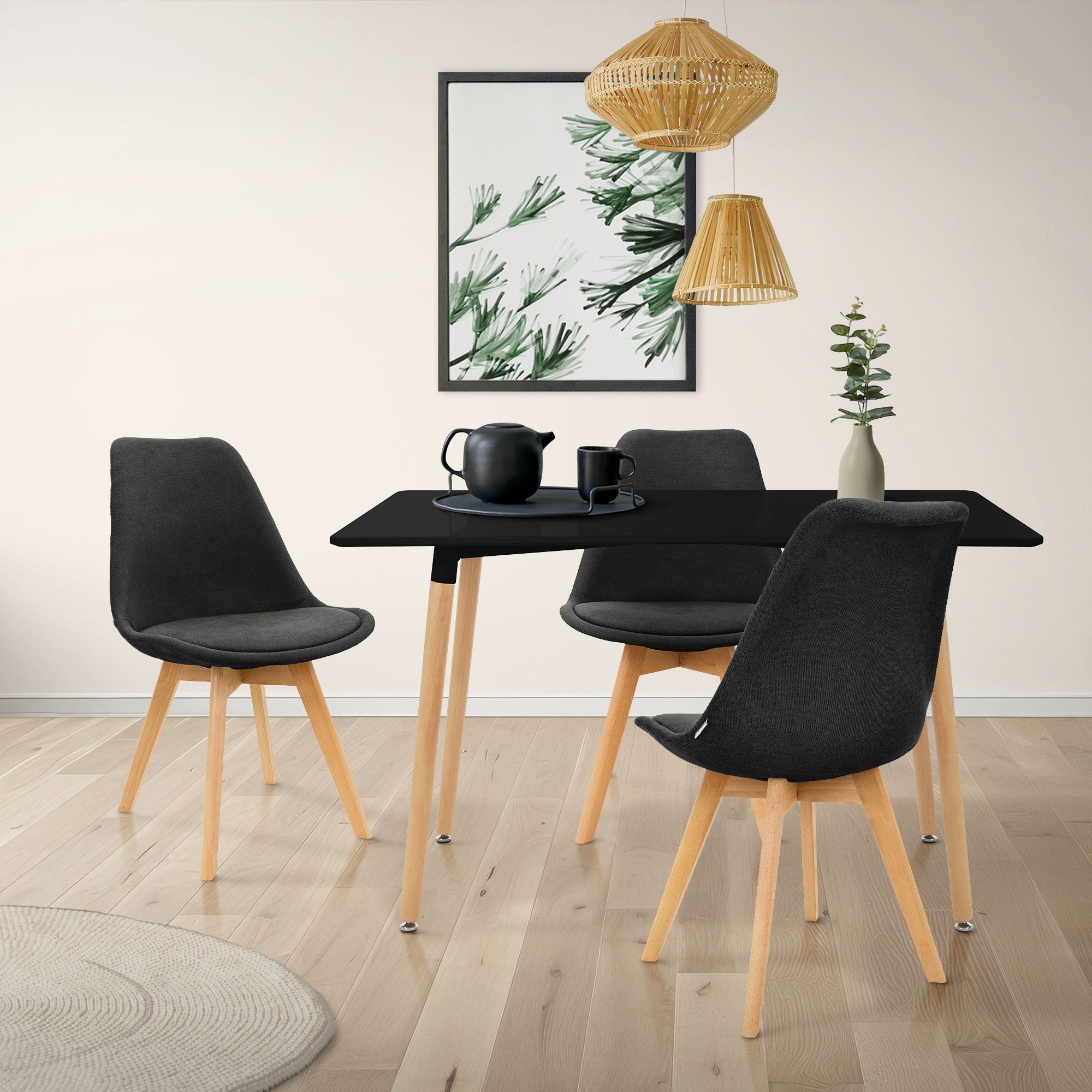 Ein Essbereich mit einem schwarzen Tisch, vier Stühlen und einer Wanddekoration.