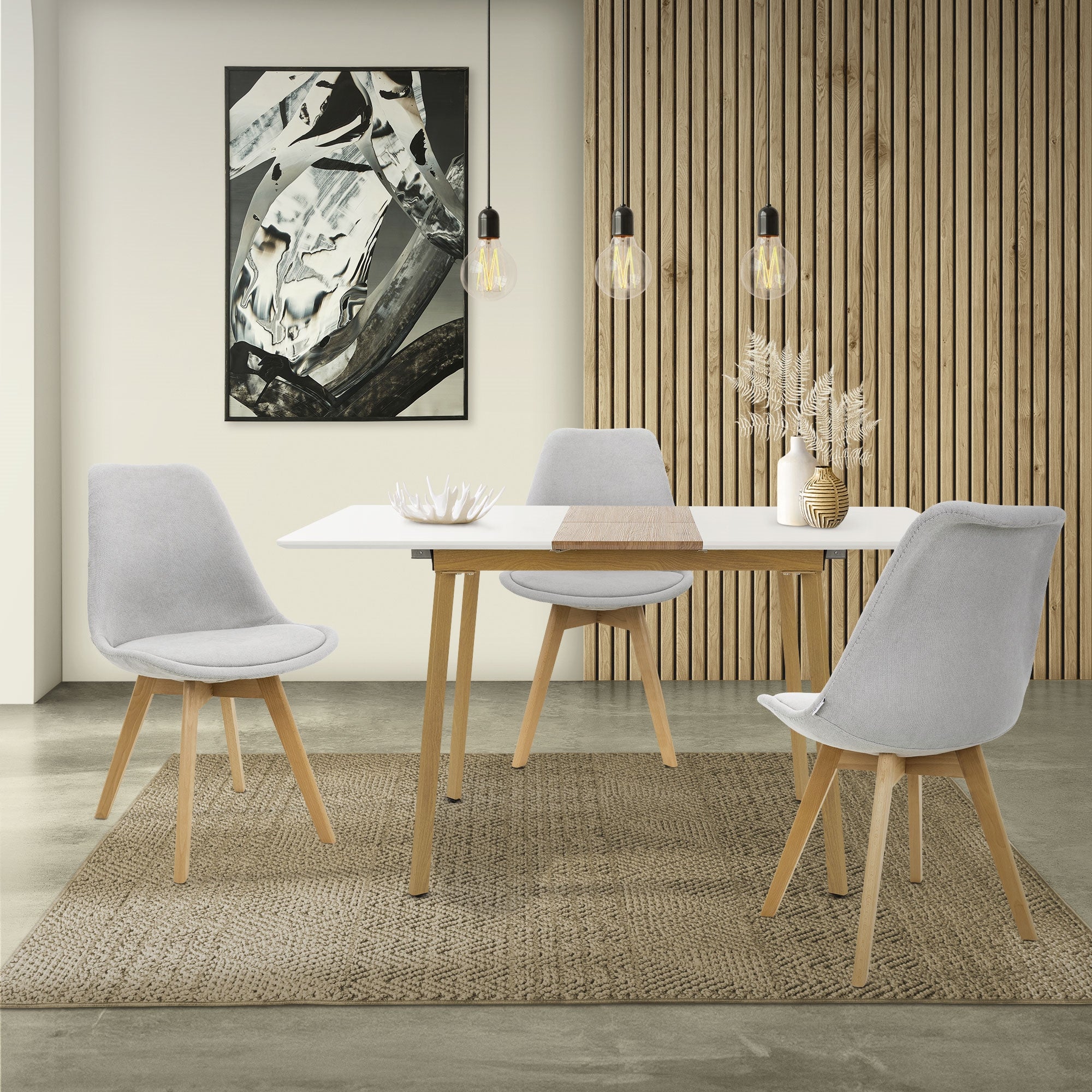 Essbereich mit einem Tisch, drei Stühlen und einer Wanddekoration.