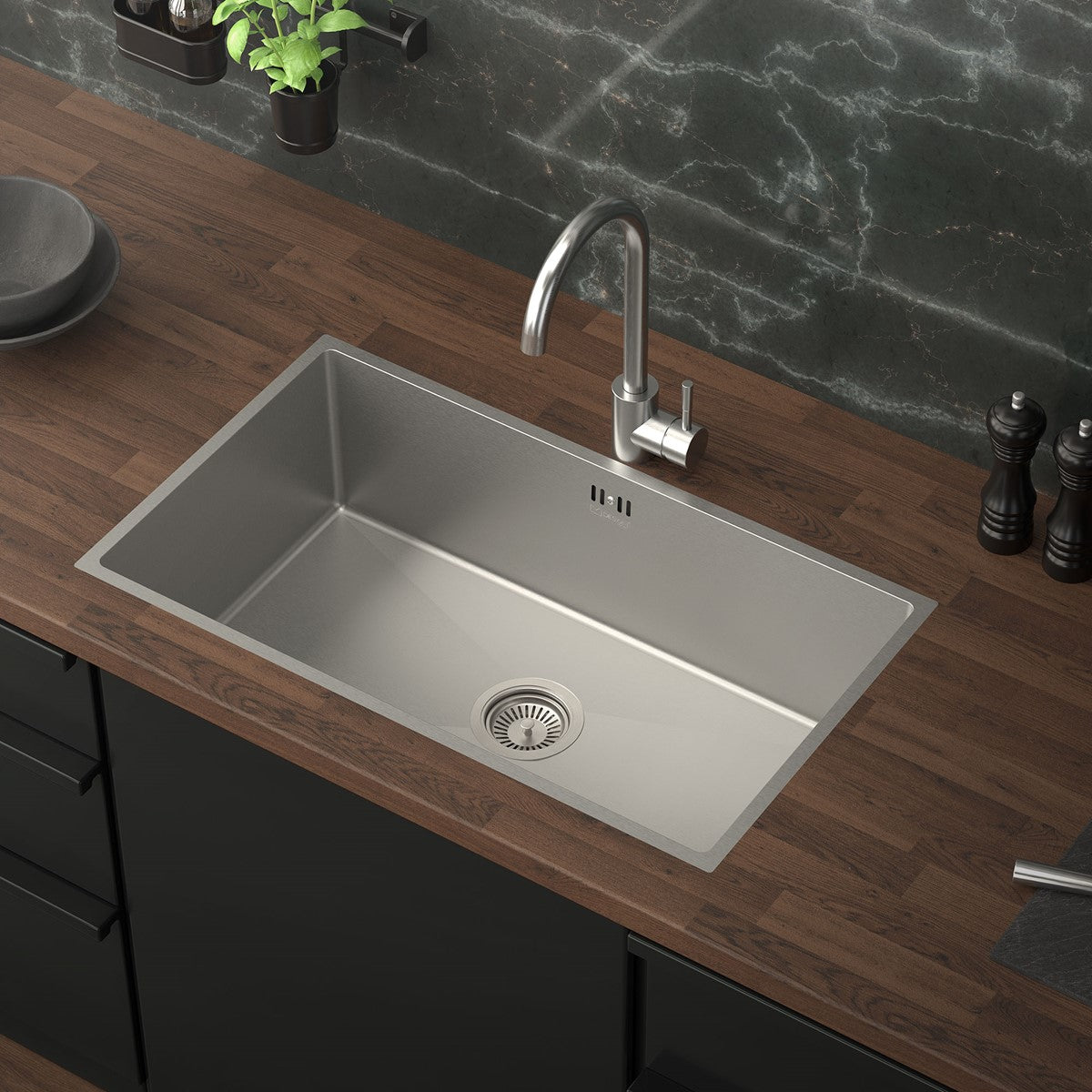 Stainless steel sink in a modern kitchen with a wooden worktop.