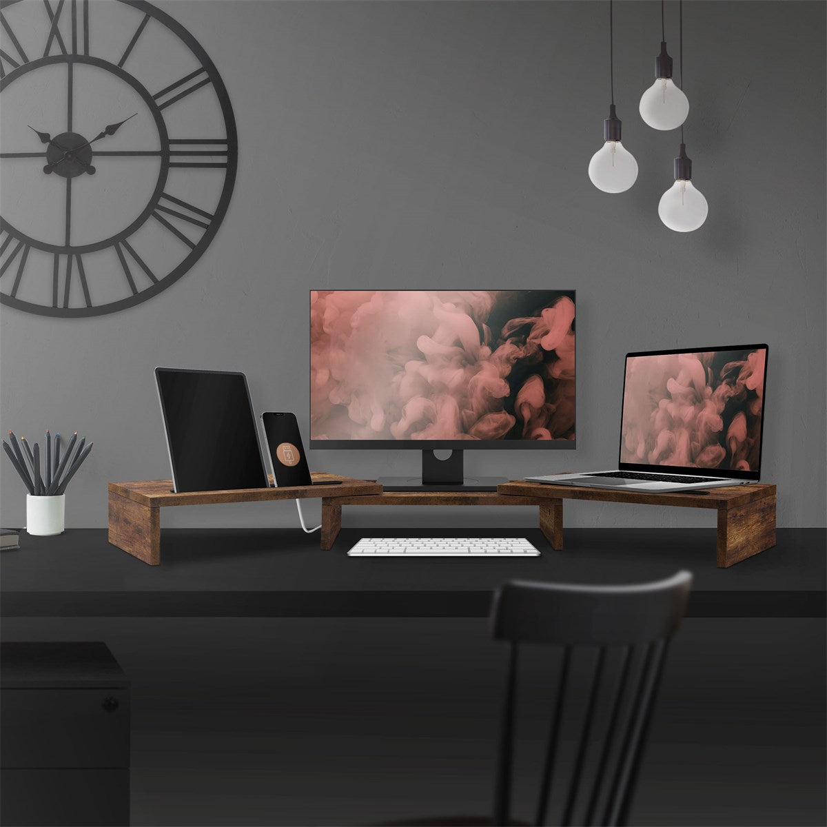 Bureau avec deux écrans, un ordinateur portable et un clavier sur des supports en bois.