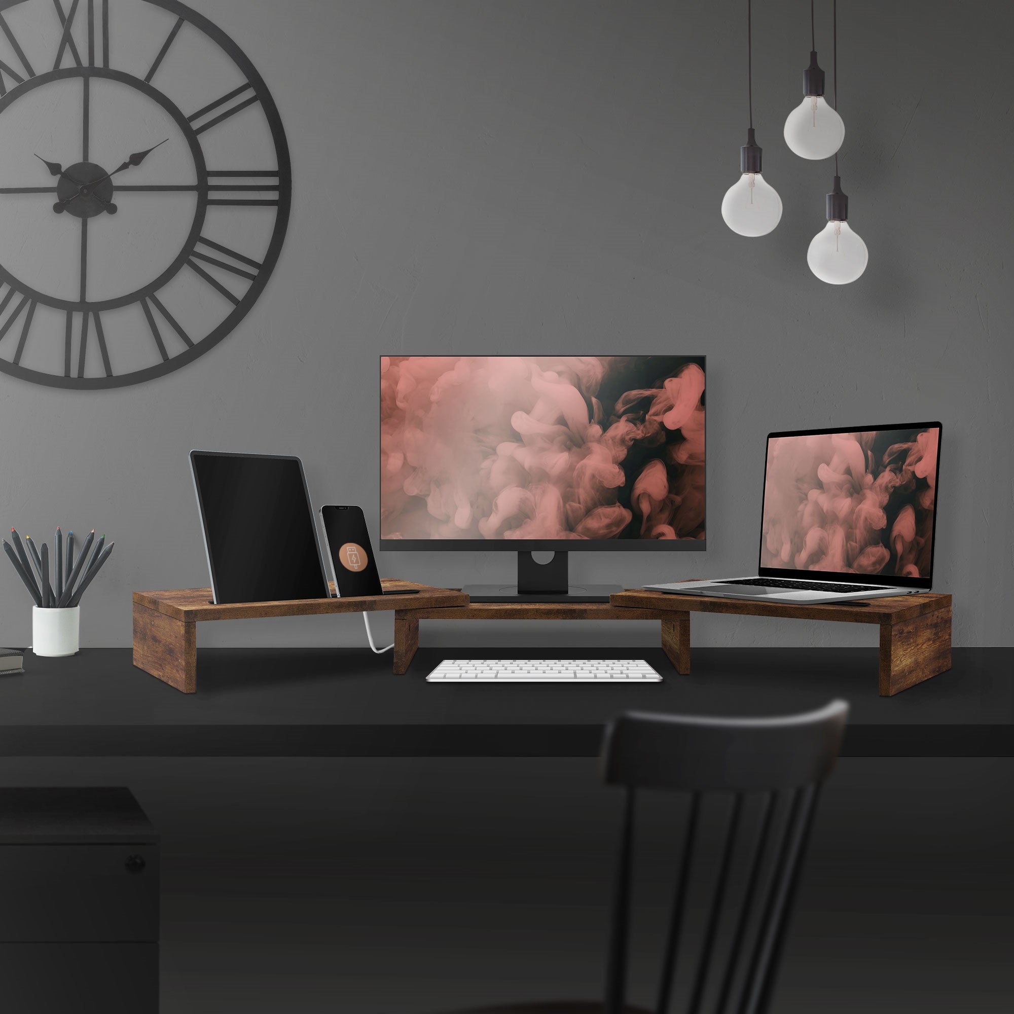 Schreibtisch mit zwei Monitoren, Laptop und Tastatur auf Holzständern.