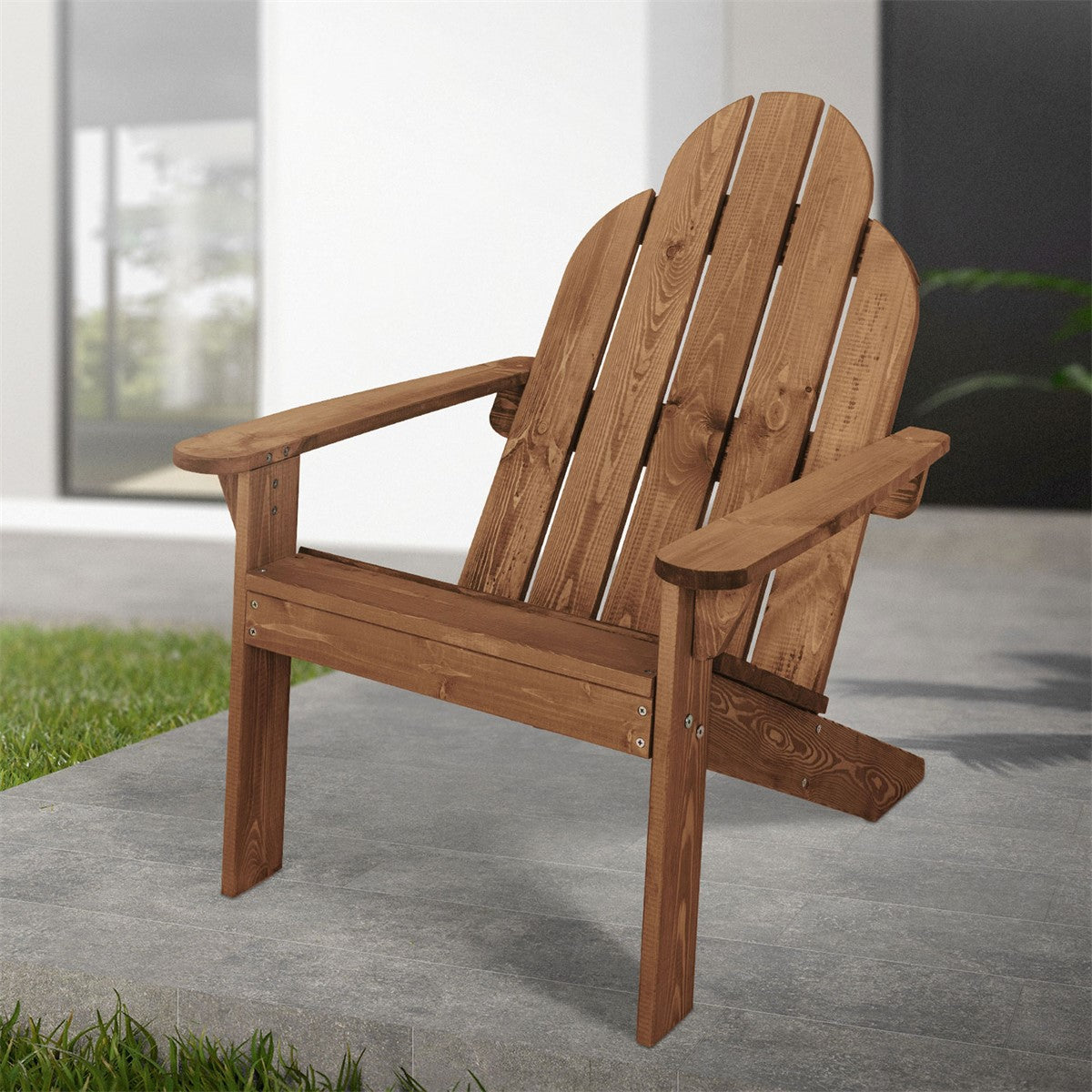 Adirondack chair on a patio, surrounded by grass and modern buildings.