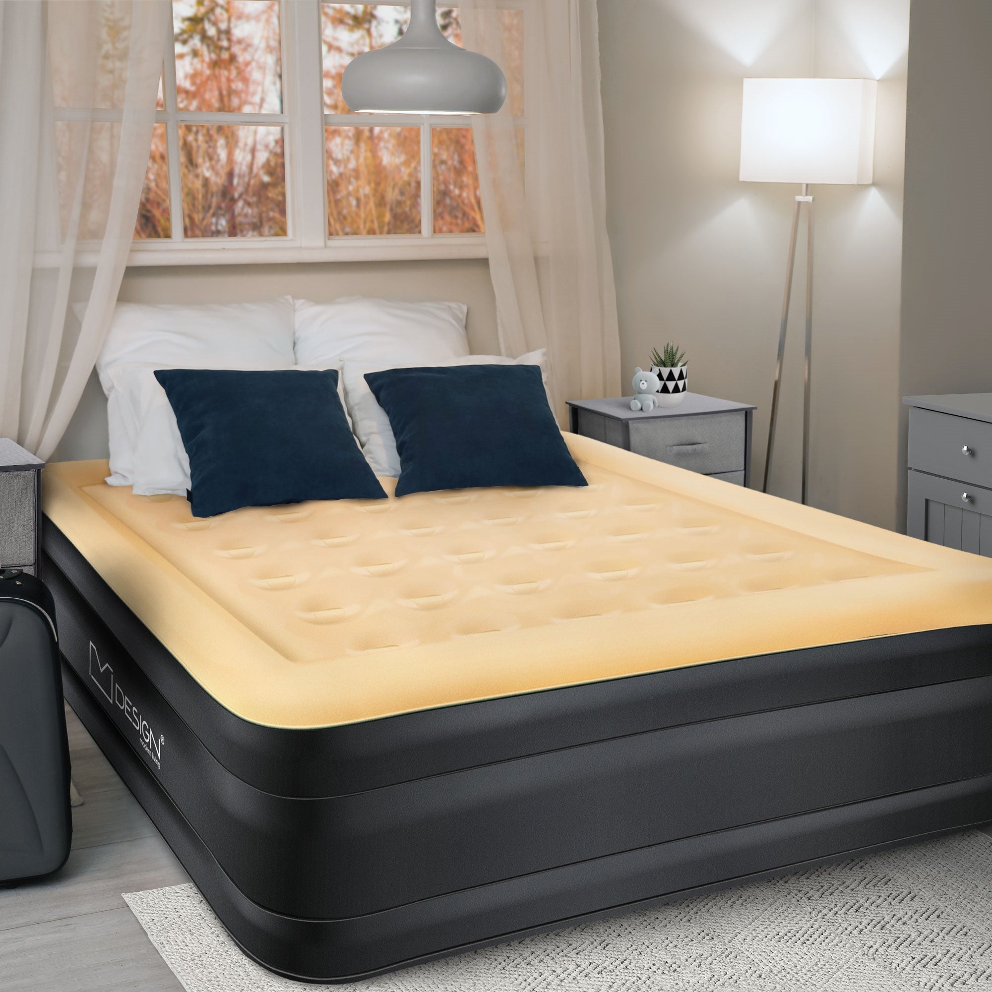 Luftmatratze in einem Schlafzimmer mit Kissen und Nachttisch.