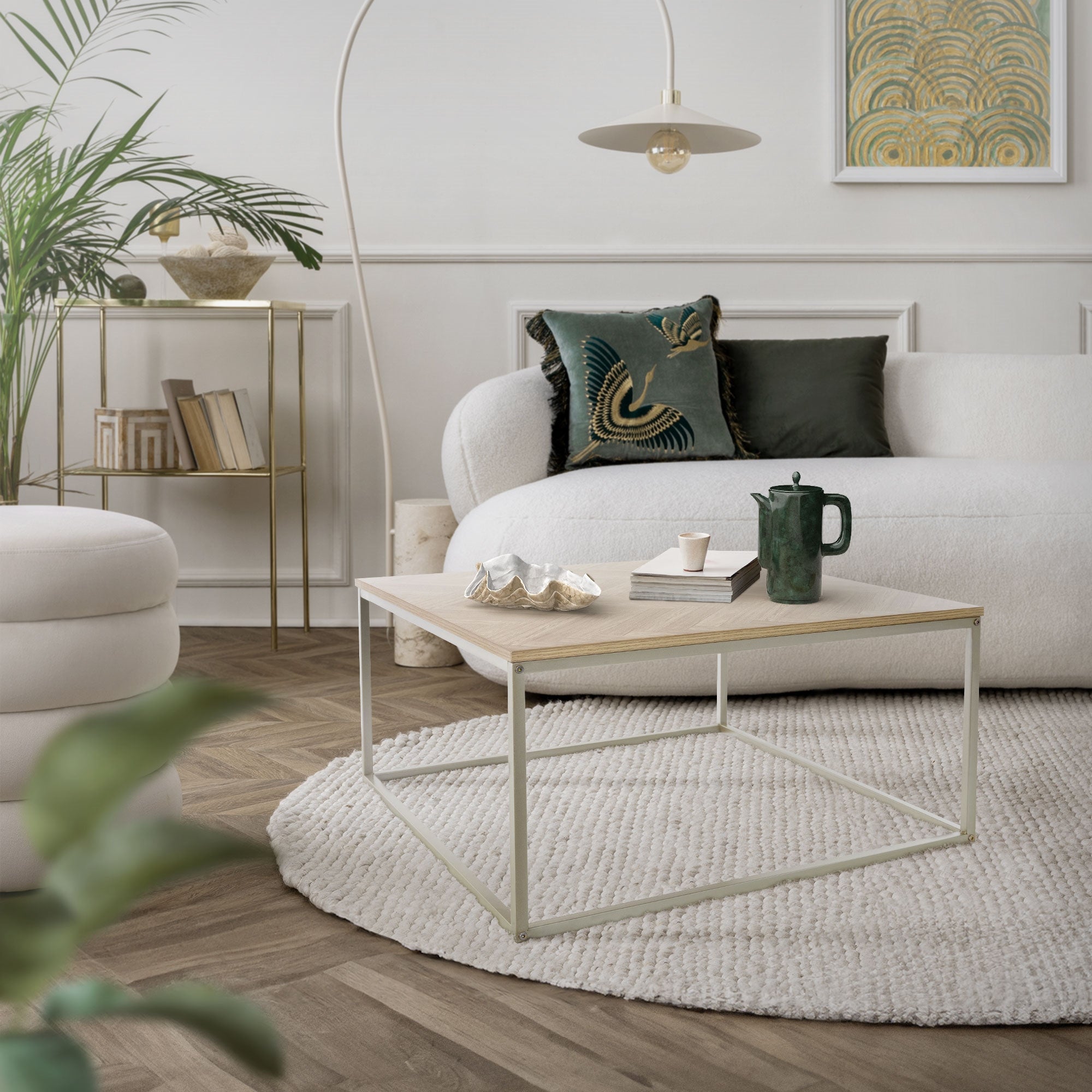 Wohnzimmer mit einem weißen Sofa, Couchtisch und Pflanzen im Hintergrund.