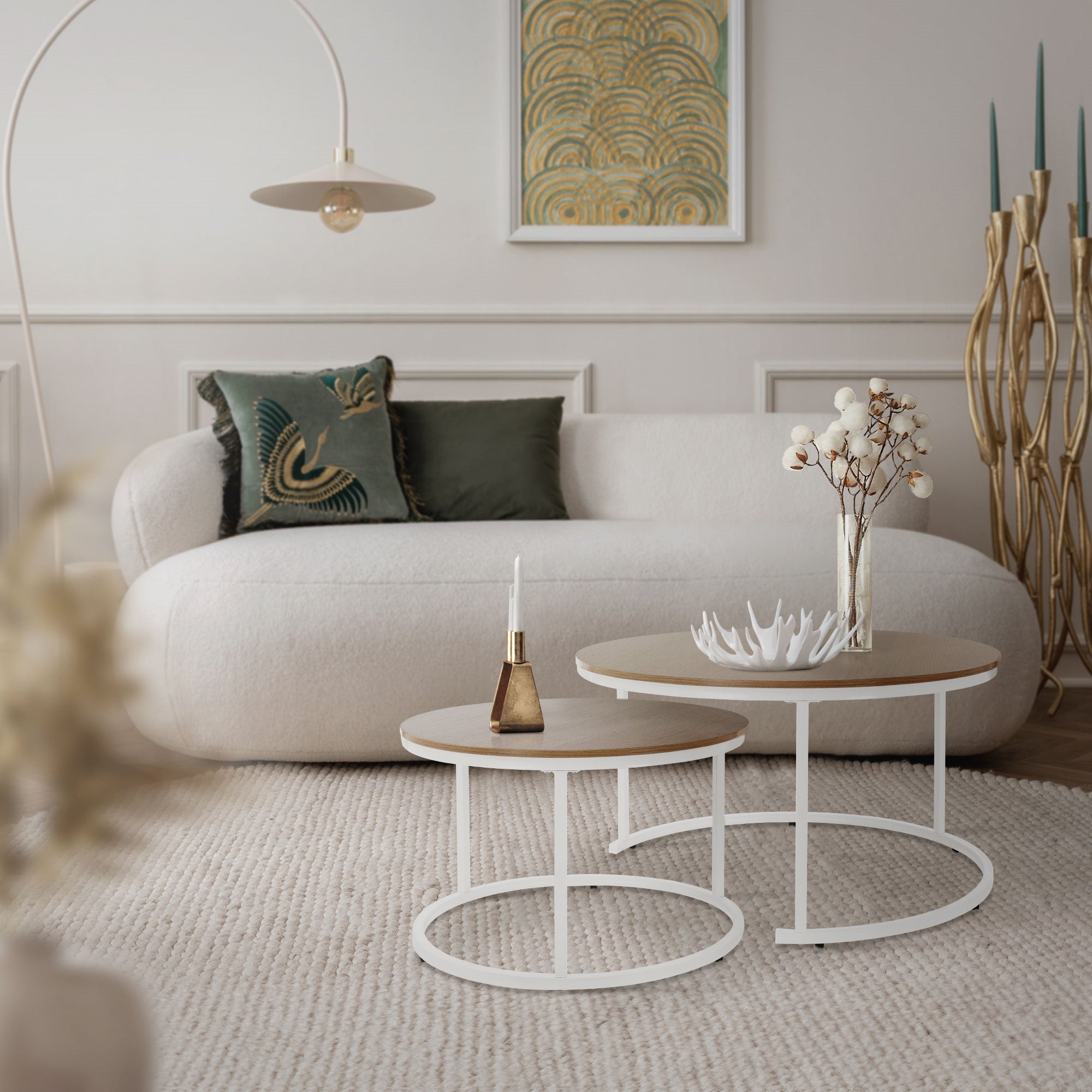 Wohnzimmer mit einem weißen Sofa, Couchtischen und einer Stehlampe.