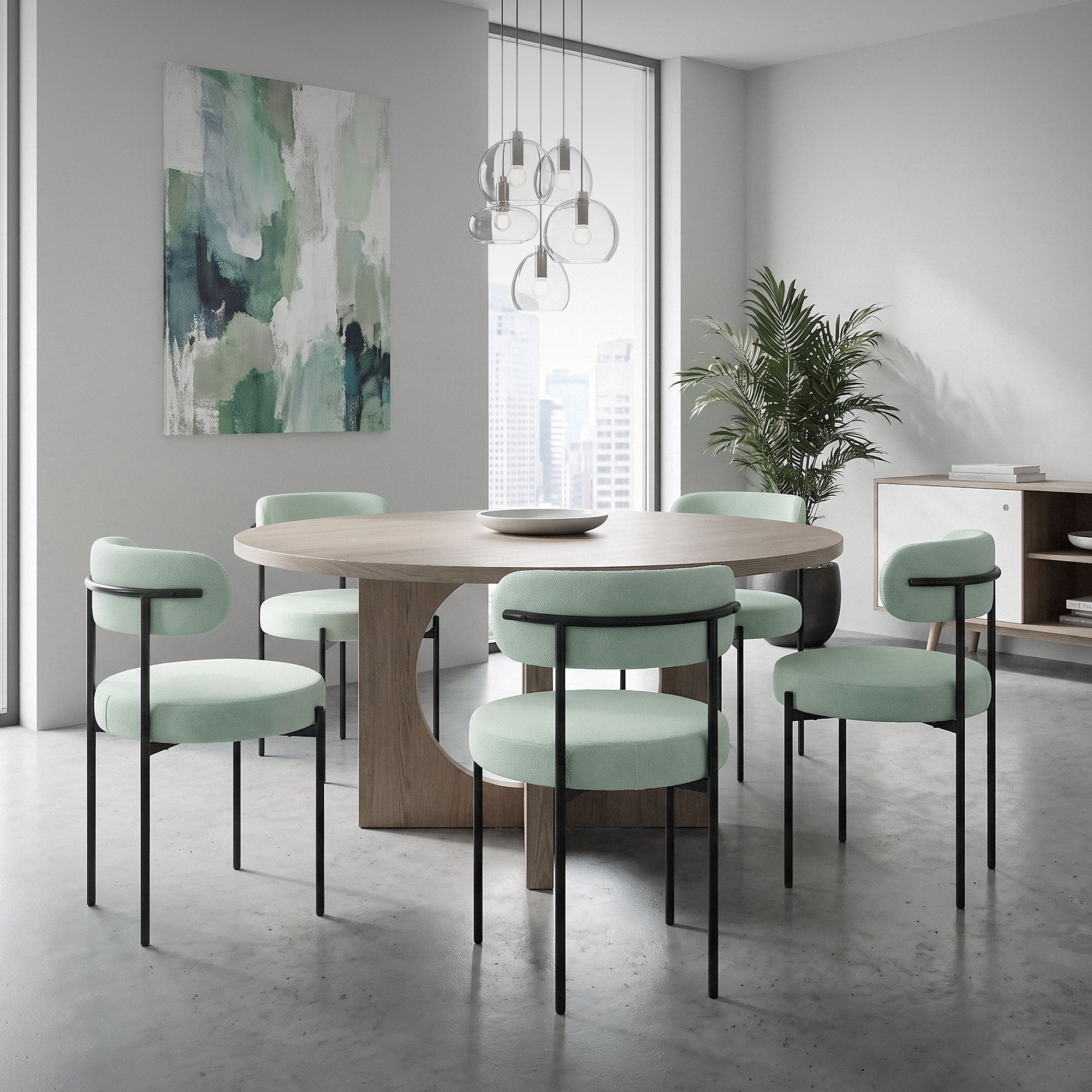 A round table with mint green chairs in a modern room with plants.