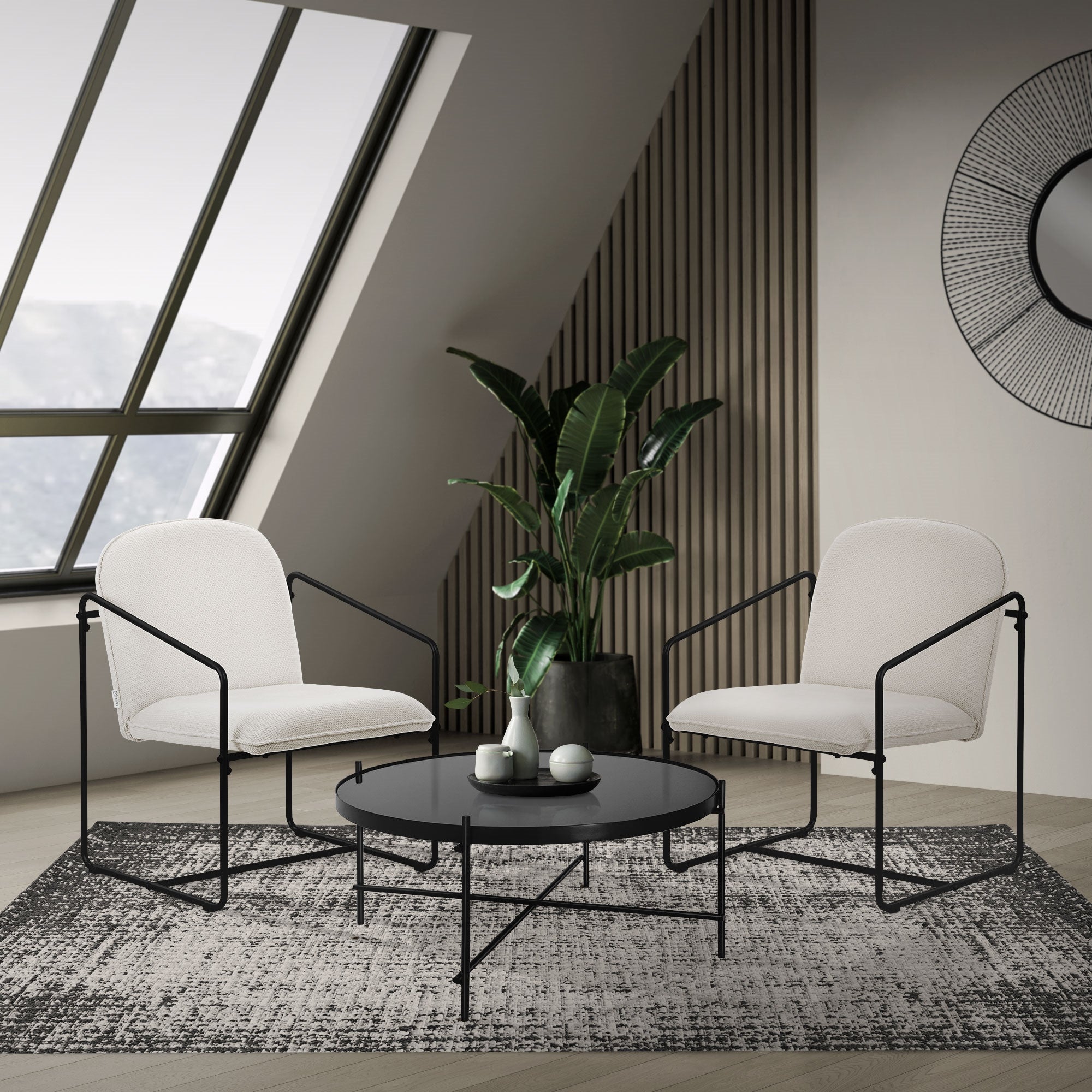 Wohnzimmer mit zwei Sesseln, einem Tisch und einer Pflanze.