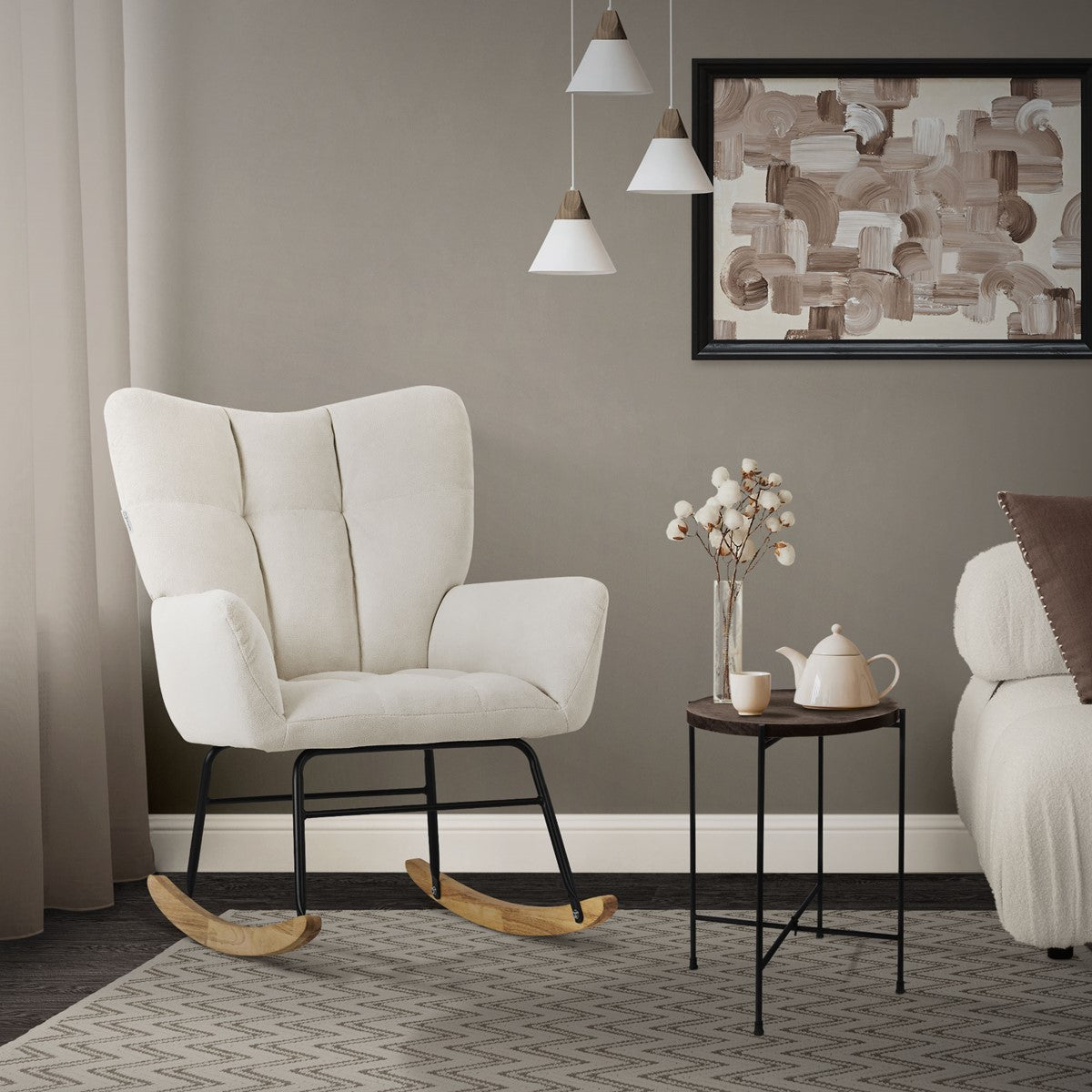 Beiger Sessel in einem Raum mit Tisch, Teekanne und Wandbild.