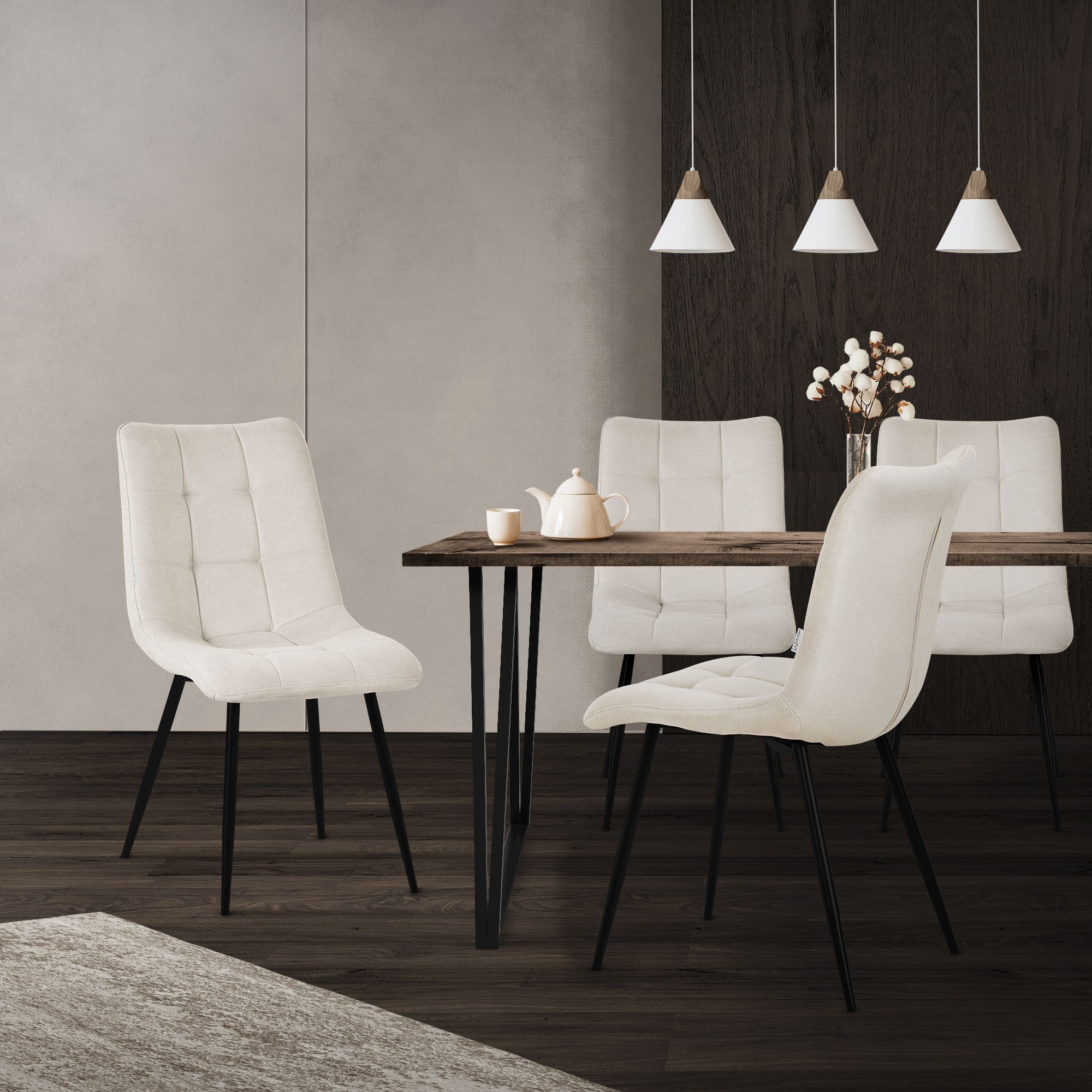 Ein Esszimmer mit einem Tisch und vier hellen Stühlen.