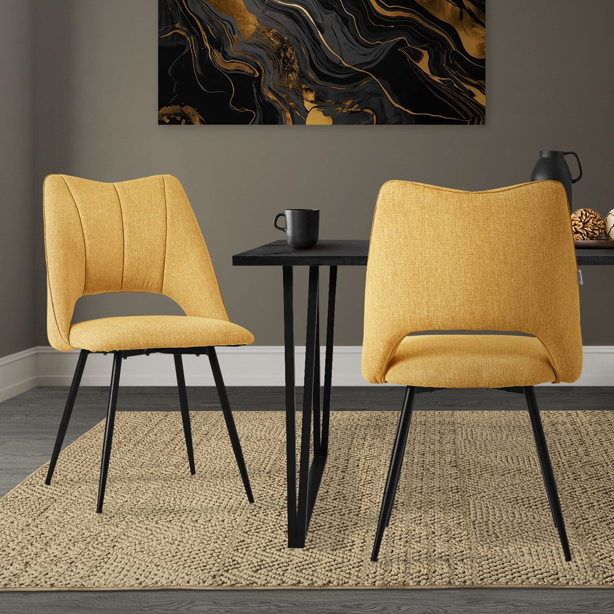 Two yellow chairs at a table in a room with a work of art.