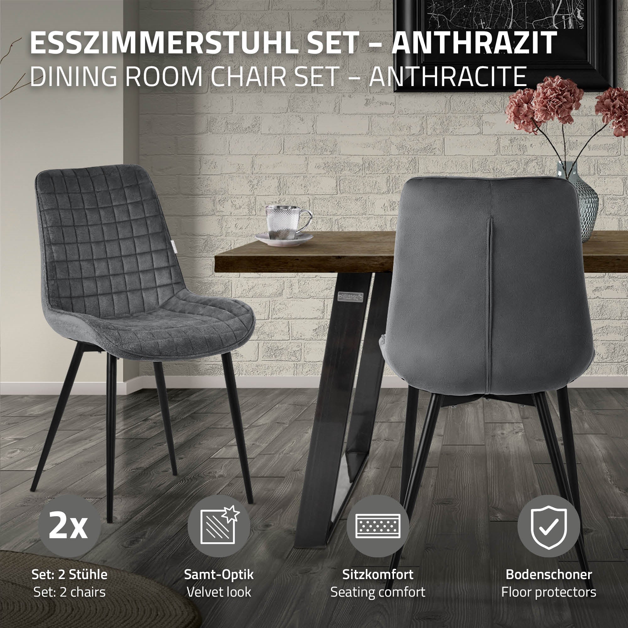 Zwei anthrazitfarbene Stühle vor einem Tisch in einem modernen Raum.