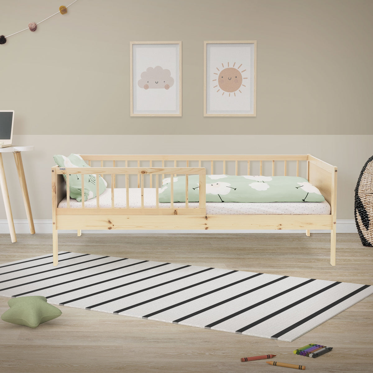 Un lit d'enfant en bois clair avec des draps verts dans une pièce.