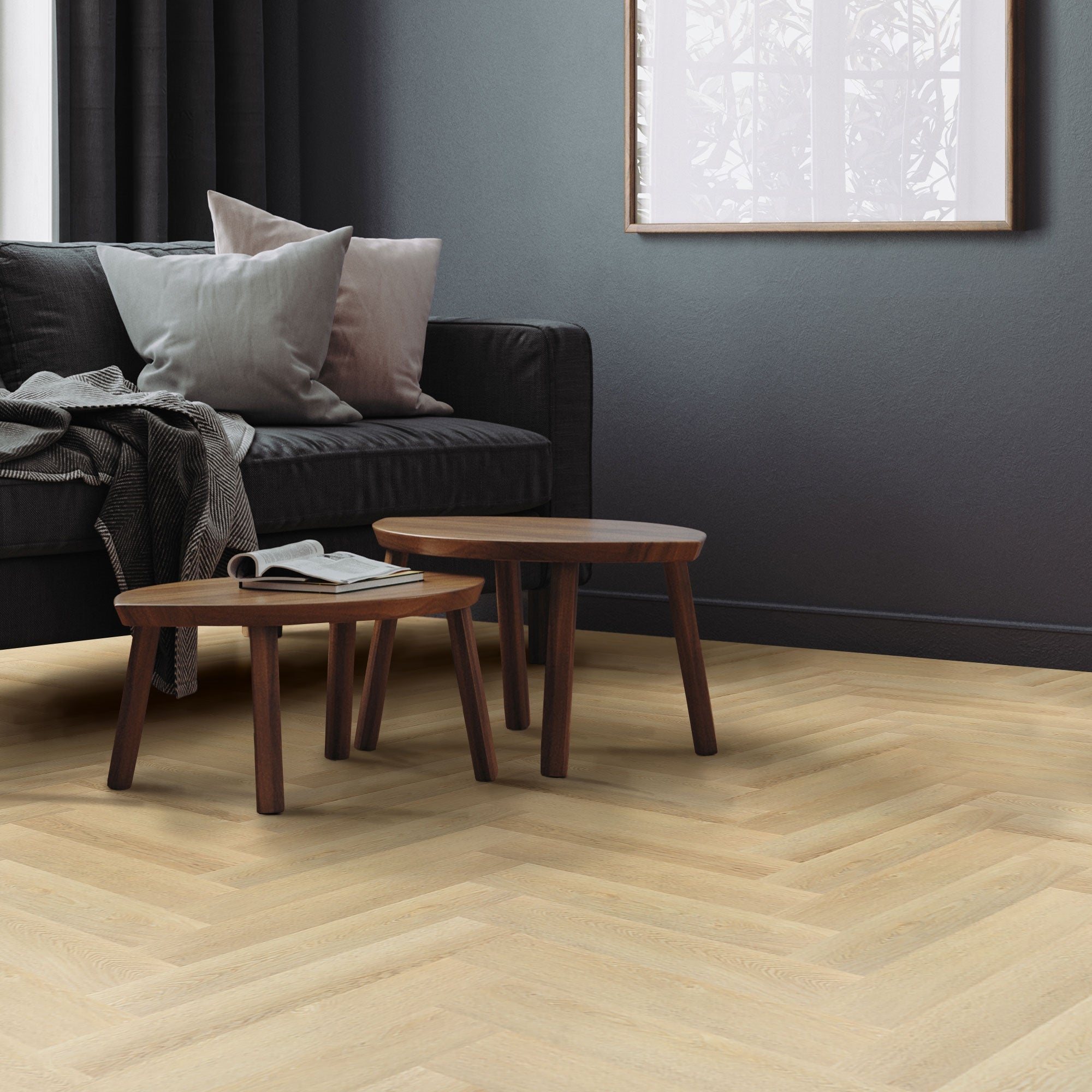 Wohnzimmer mit Sofa, Kissen und zwei kleinen Tischen auf einem hellen Holzboden.