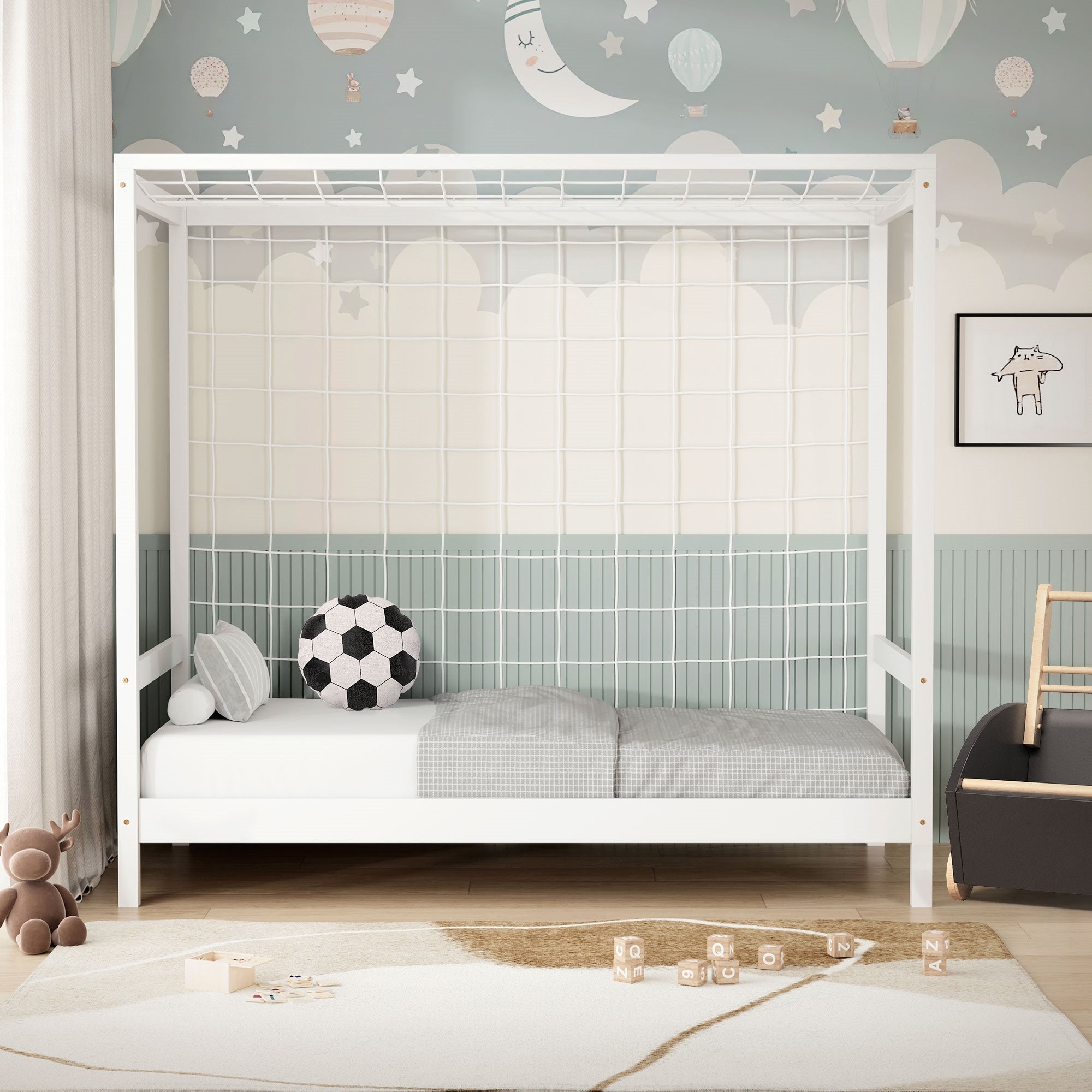 Ein Kinderbett mit Gitter und Kissen auf einem Teppich in einem hellen Raum.