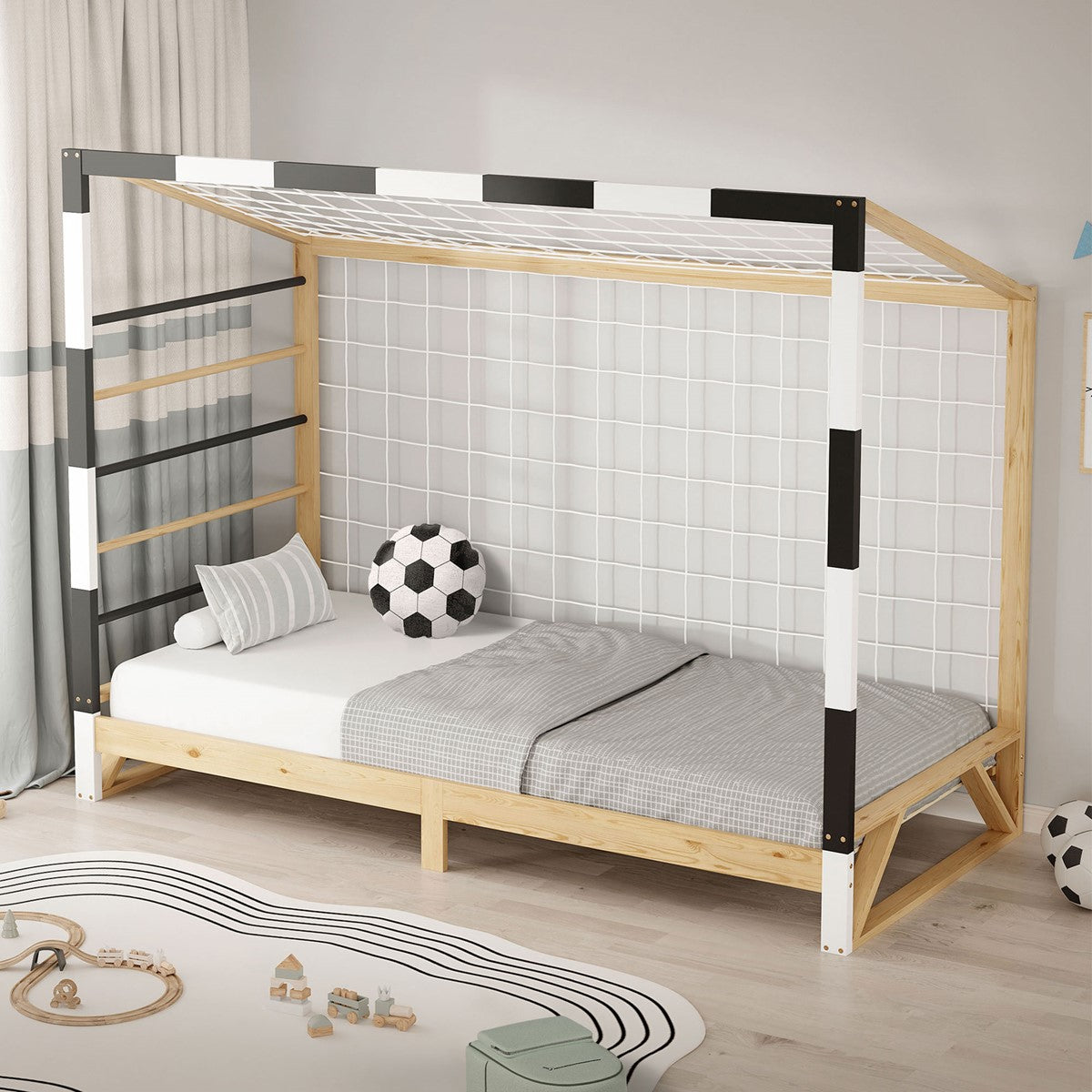 Ein Bett mit einem Gitter und einem Fußball auf dem Boden.